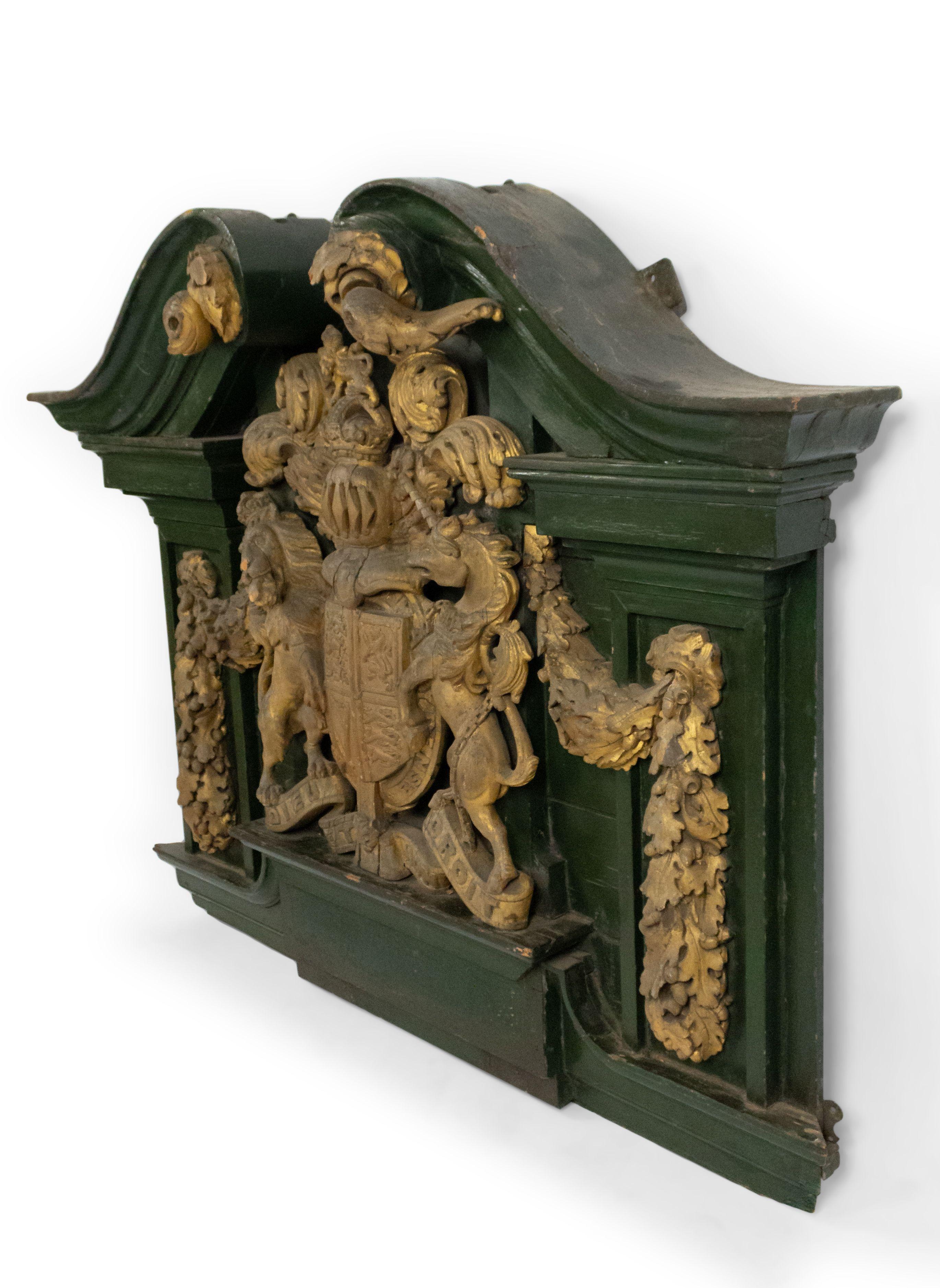 Englische georgianische (18/19. Jh.) grün bemalte und geschnitzte vergoldete Wandtafel mit Wappen mit Einhorn und Löwe und gebrochenem Giebelaufsatz.
