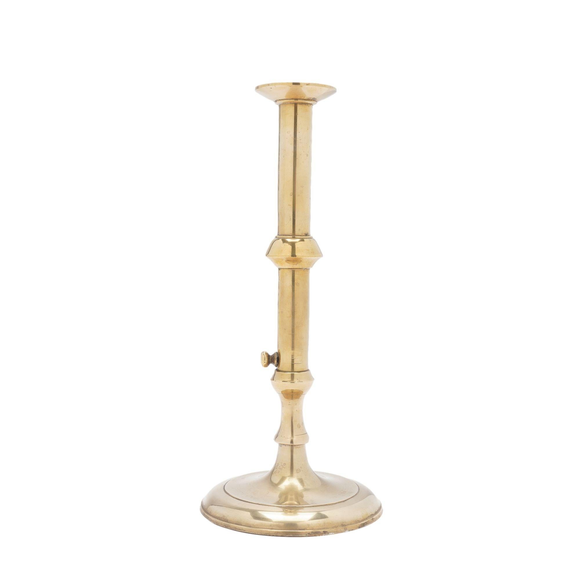 English Georgian cast brass cannon barrel candlestick with external push-up. The candlestick is a seam cast construction and the shaft has been peened to the circular domed base.

England, circa 1740.