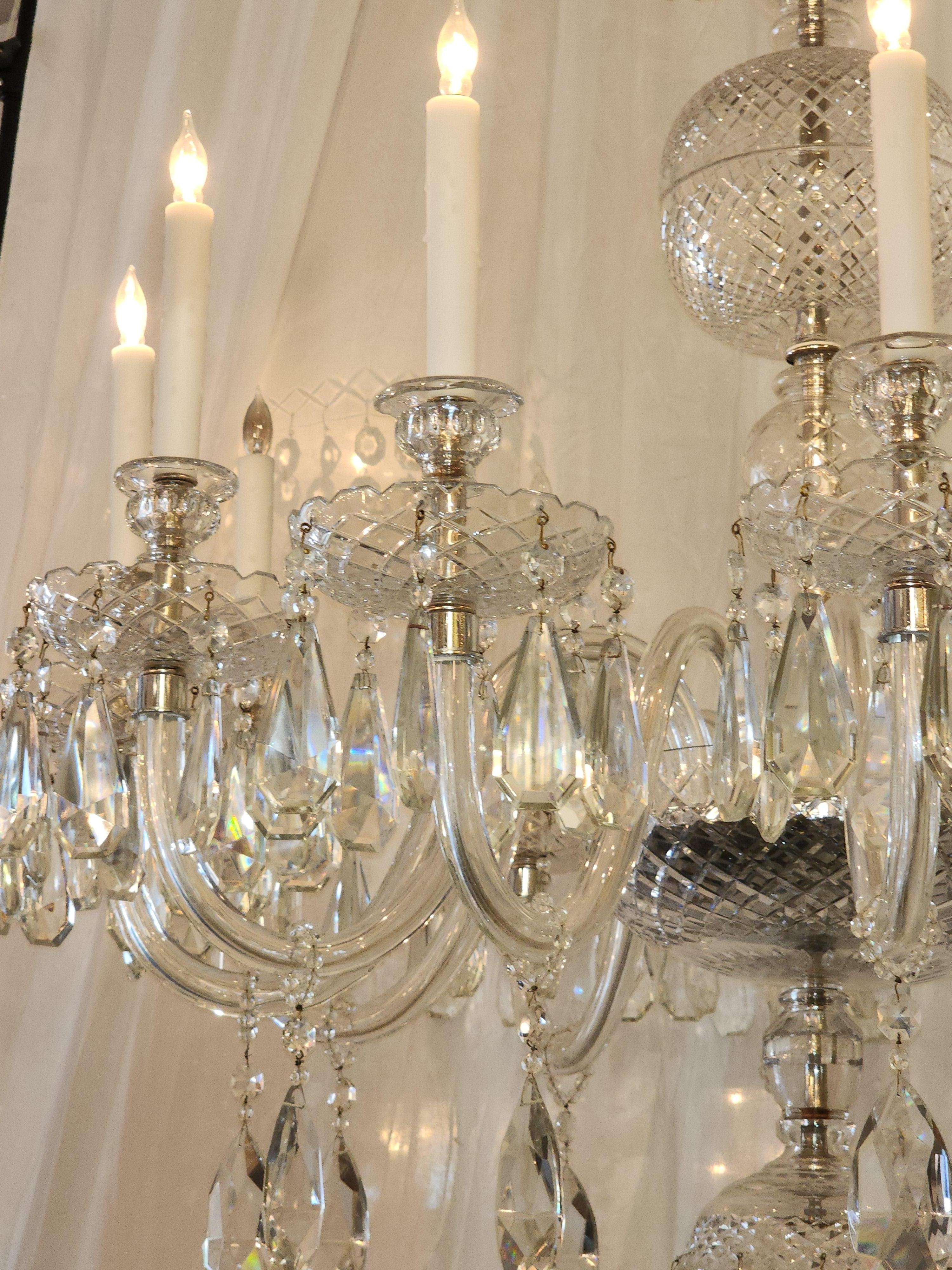This English Georgian chandelier is dressed in kite and half pear crystal. The central stem of this semi large chandelier is cut German crystal.