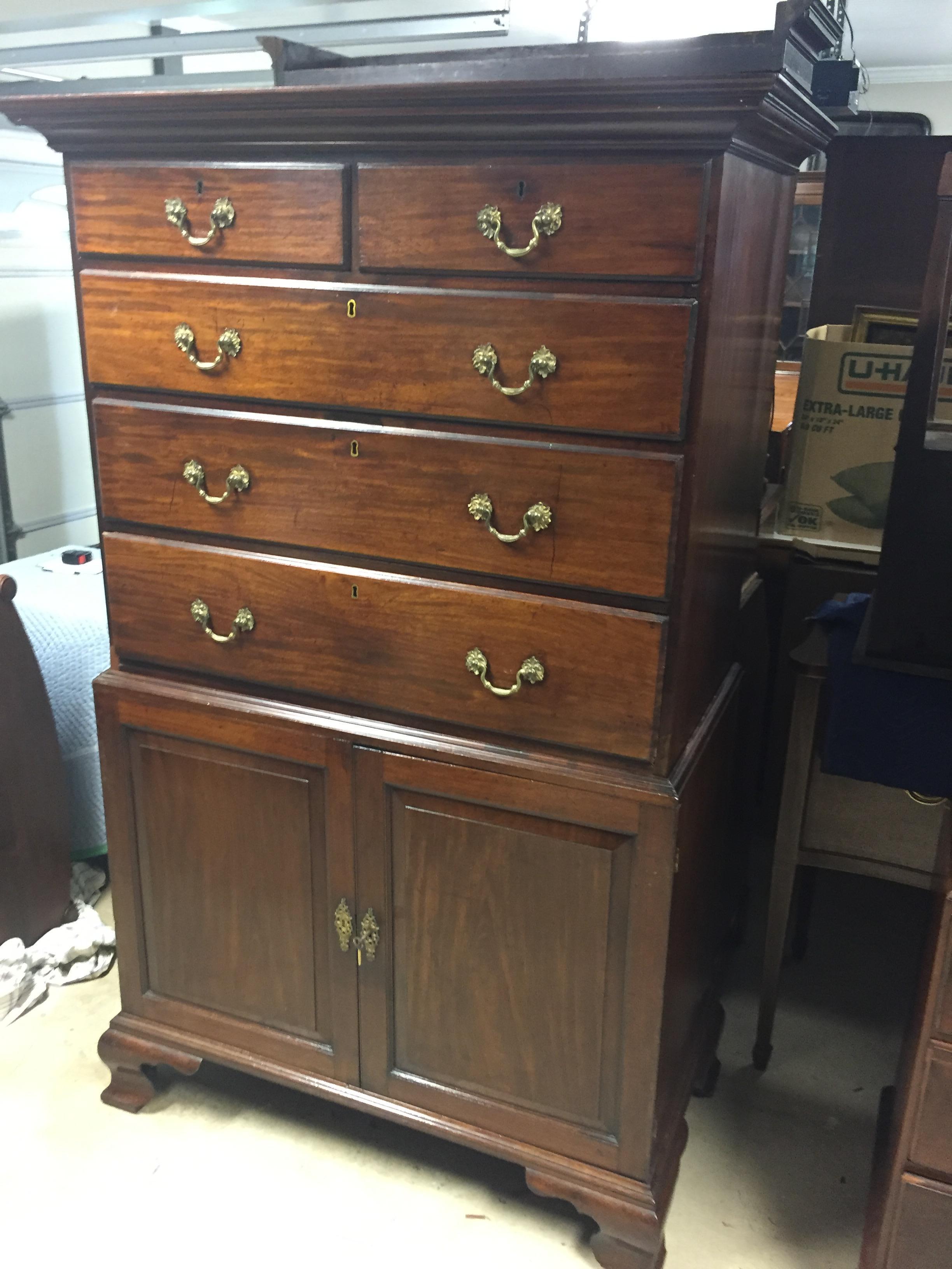 English chest on chest with solid mahogany, beautiful color and patina, large period feet, drawers on top and doors and slides on the lower case. Two part construction, original crown. Replacement brass pulls, a solid, heavy, impressive tall chest.