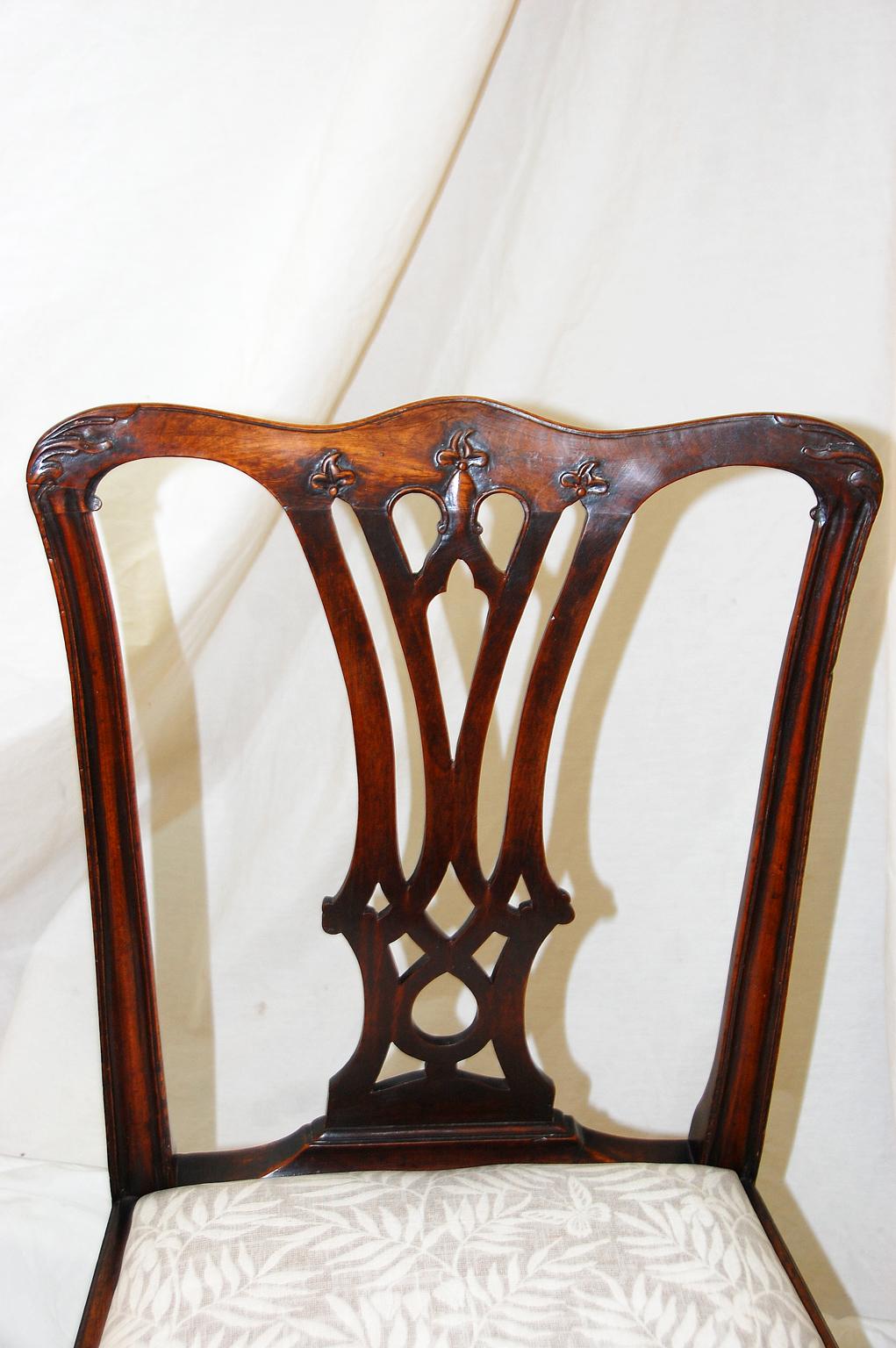 English Georgian Chippendale period pair of mahogany carved side chairs. The back top rail is carved with acanthus leaves to the corners and trefoil leaves in the center, the central splat is nicely pierced and the side uprights are molded. The