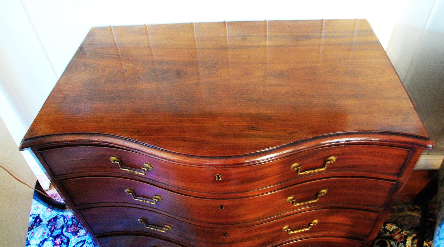 English Georgian Chippendale period mahogany serpentine chest of four graduated molded edge drawers, bracket base. Small size and stylish height makes this serpentine chest particularly desirable, circa 1790.