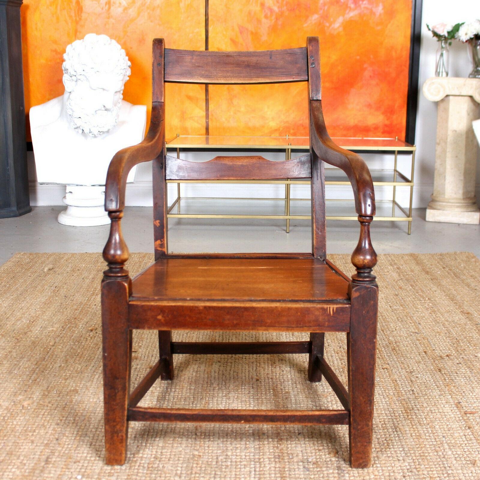 An impressive George IV period fruitwood armchair.

Of plain rustic form with fluted top rail and cross splat above a solid elm seat flanked by fluted armrests and raised on square section legs with stretchers.
