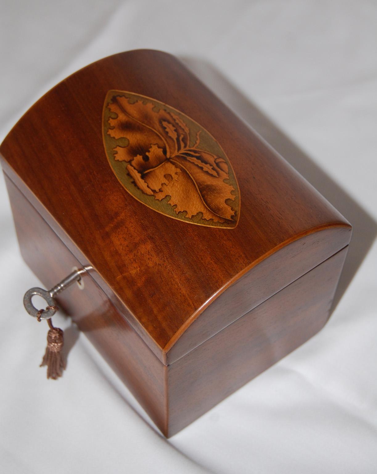   English Georgian mahogany domed top tea caddy.  This single tea caddy has a sycamore oval inlay to the lid with shaded boxwood oak leaves and acorn, inlaid into the oval.  The sycamore retains its natural green color which sets off the  shaded