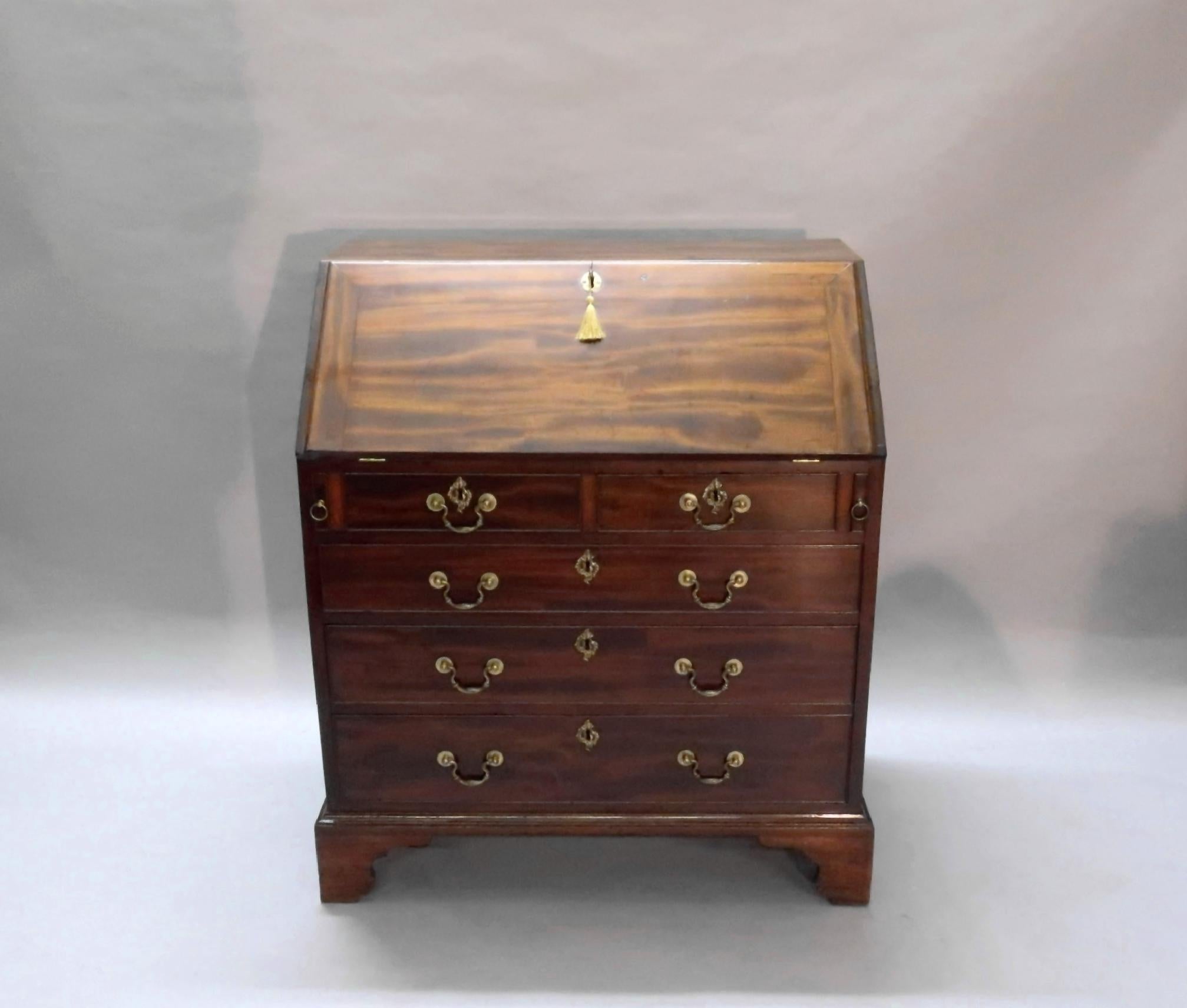 An exceptionally fine quality small Georgian Honduras figured mahogany bureau stood on its original bracket feet with original decorative swan neck handles and key escutcheons. The interior of the bureau has a central cupboard, eight mahogany and