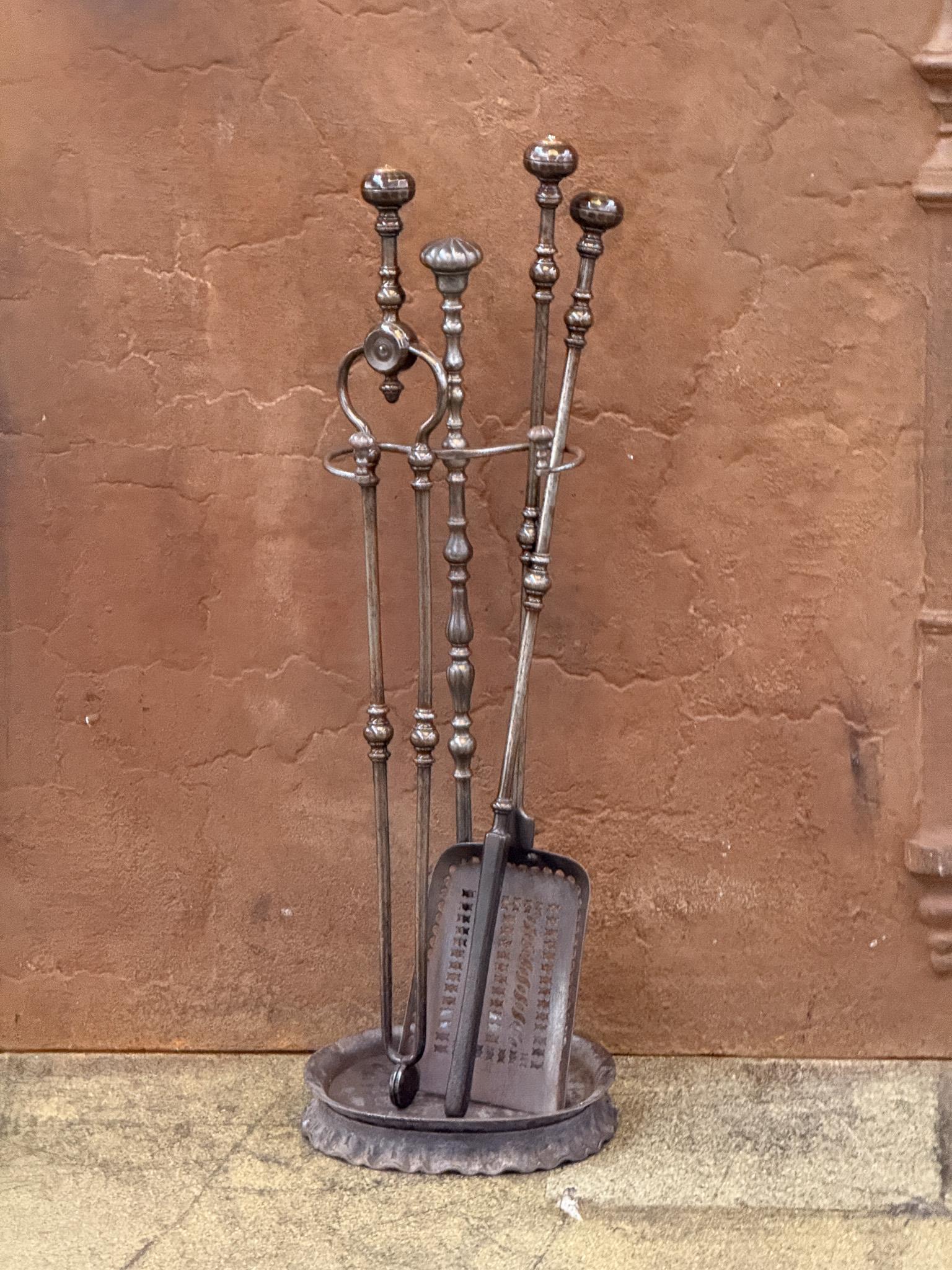 Set of three beautifully crafted Georgian fireplace tools made of wrought iron and brass with a stand. Early 19th century. The fire tool set is in a good condition and is fully functional.