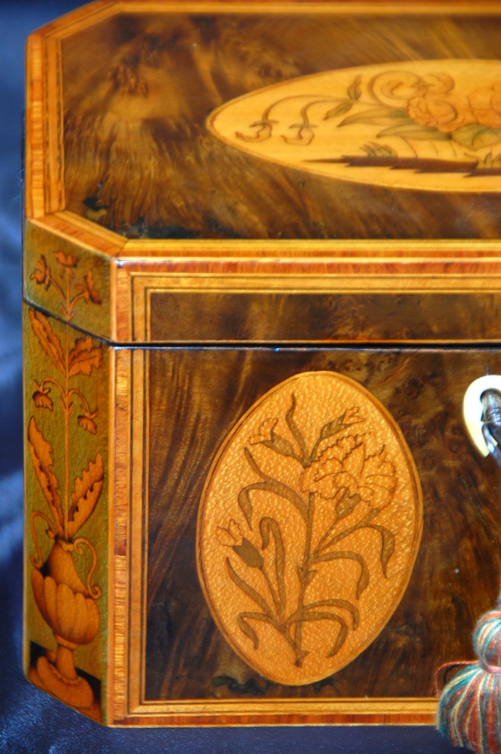 English Georgian harewood octagonal inlaid double tea caddy. The top and front of this fine tea caddy have satinwood ovals inlaid with various flowers in boxwood and sycamore. The front corners have elaborate boxwood inlay on sycamore ground of urns