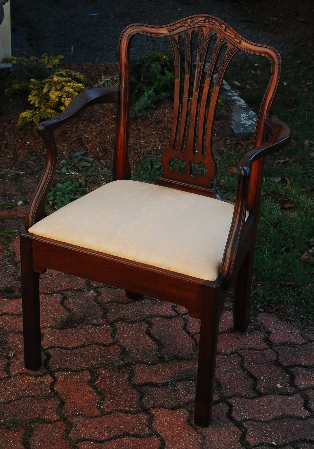 Ref. #4556. English Georgian Hepplewhite mahogany armchair of bold proportions, with wheatsheaf and ribbon carving to the back, and carving to the graceful arms.  The arched top rail and wide pierced carved central splat are well executed as one