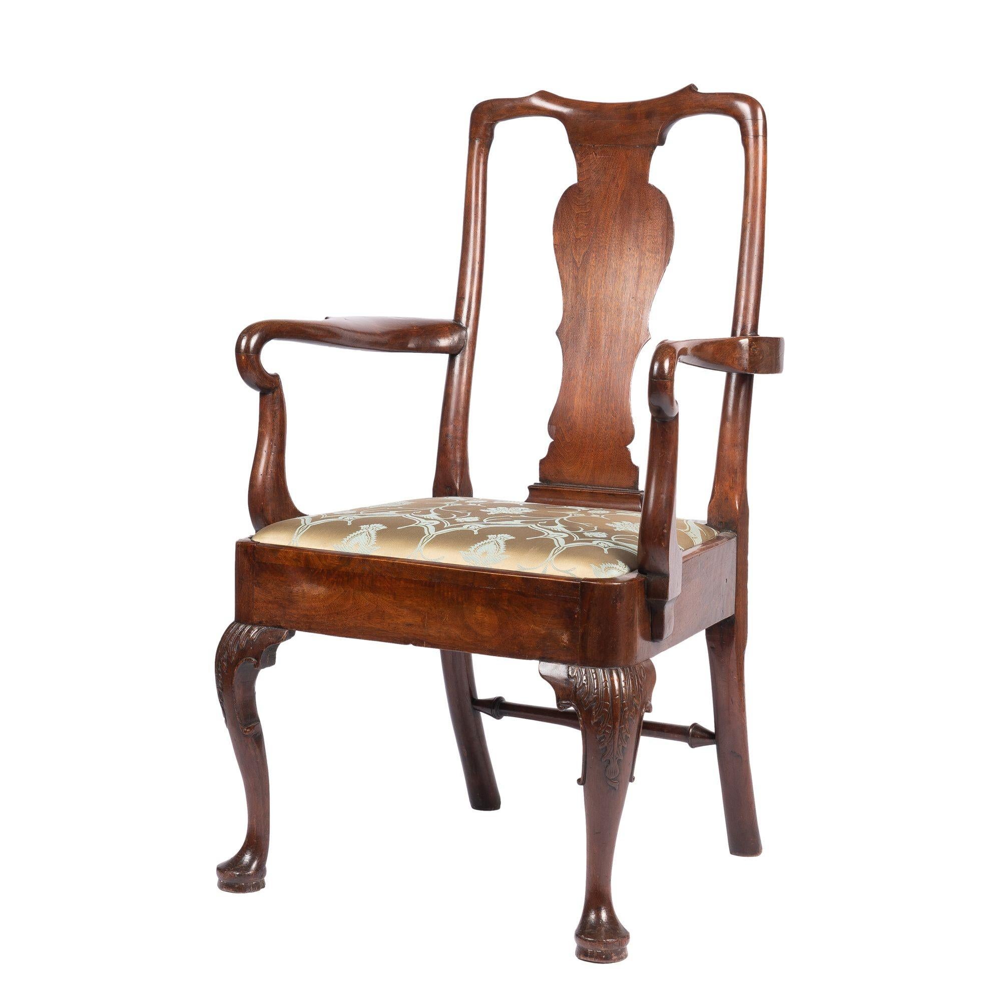Queen Anne / George I chair with shepherd crook arms and vasiform splat beneath a yoke crest rail. The upholstered slip set is supported by cabriole front legs which terminate in a pad foot.

England, circa 1720.