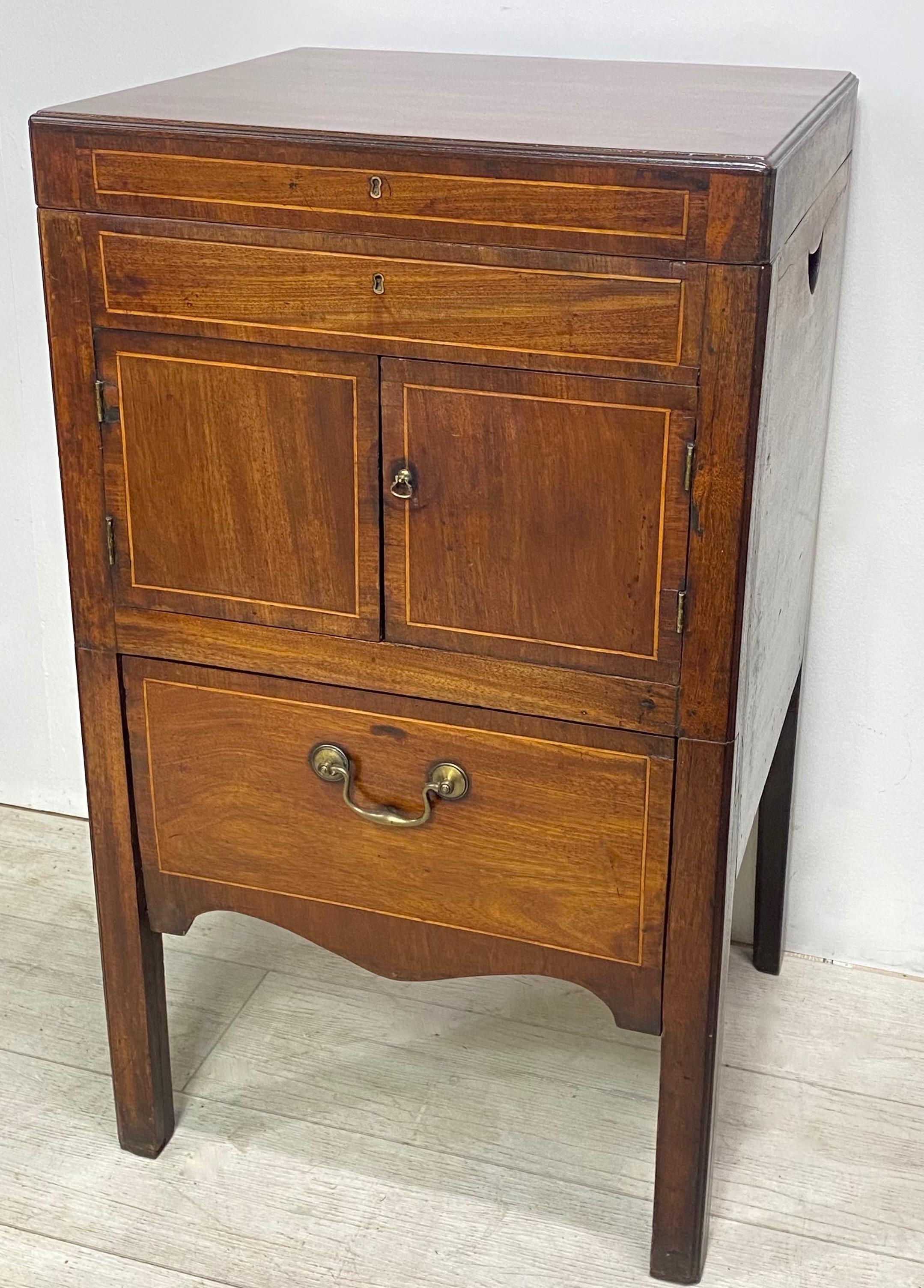 A George III mahogany bedside table cabinet commode with satinwood stringing inlay.
England, 1810-1820. 
We have refinished the top of this piece, the rest retains its original finish and warm patina.
  