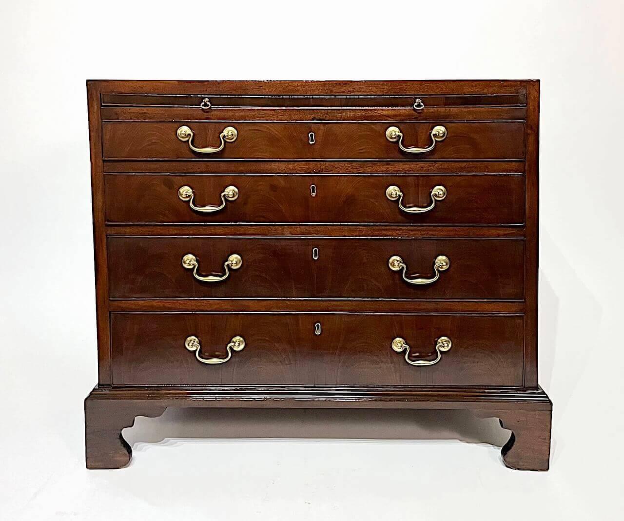 A fine English late George II, early George III period mahogany bachelor's chest of rectangular form, the square edge or 'caddy' top with cross-banded border above cockbeaded brushing slide and four graduated drawers with lovely bookmatched crotch