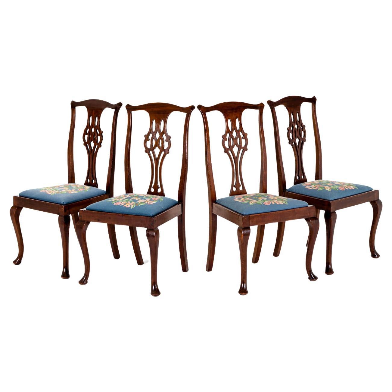 Un set di quattro sedie da pranzo in mogano di epoca tardo georgiana con cuscini di seduta a ricamo floreale.

Le sedie presentano un'asta sagomata con orecchie intagliate sopra un'alzatina in stile Chippendale, traforata e intagliata con volute e