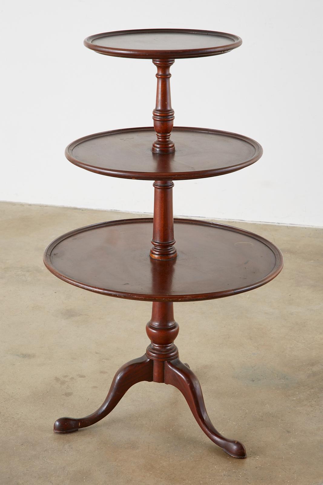 Fine English mahogany dumbwaiter constructed in the Georgian taste. The graduating tiers measure 25 inches, 20 inches, and 15 inches across. Each tier is attached to a turned column supported by three cabriole legs ending with pad feet. Excellent