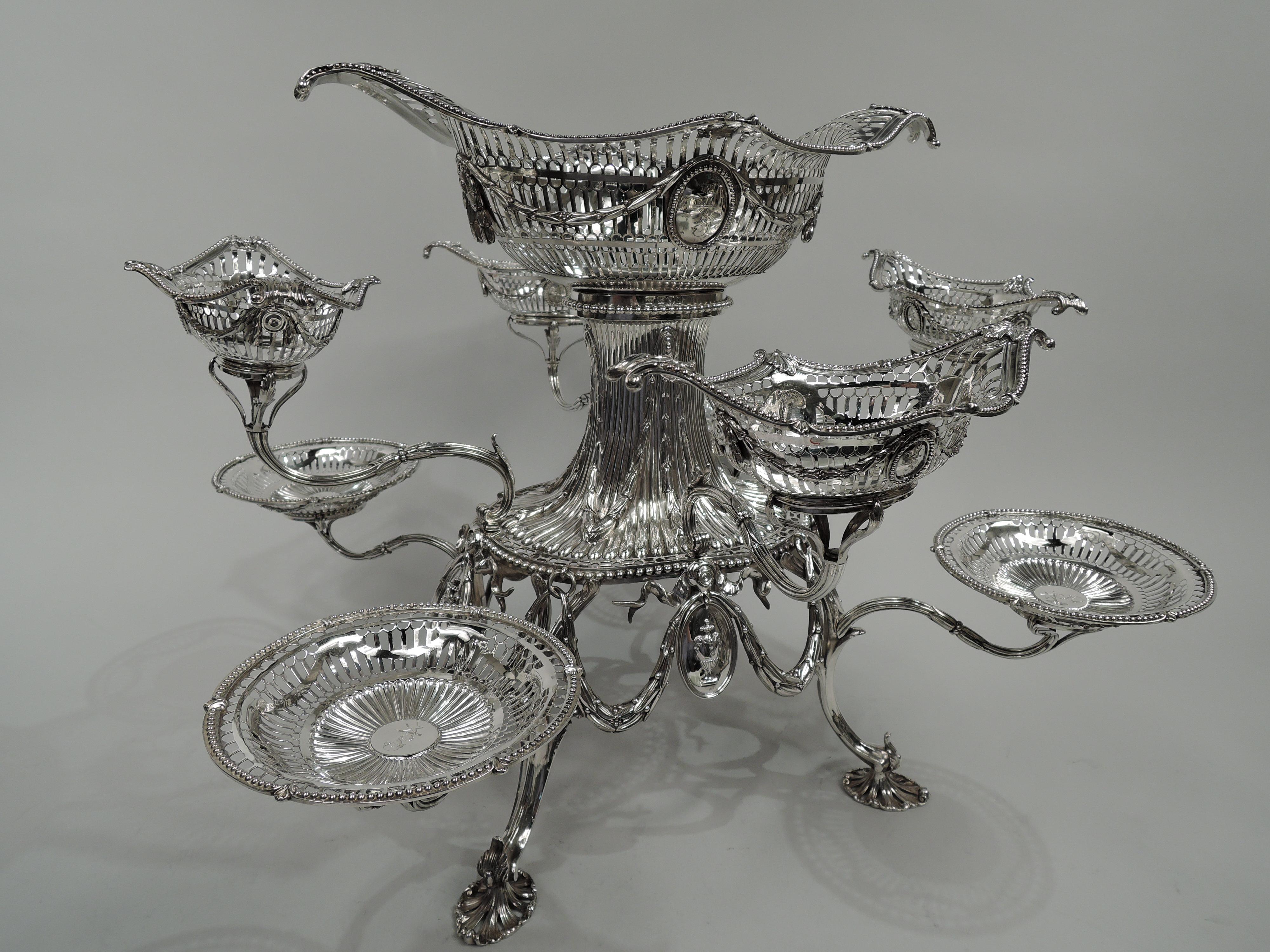 George III sterling silver epergne. Made by Thomas Pitts in London in 1774. Reeded and beaded oval frame; at base swags threaded through fixed rings with pendant oval vase medallions, overlapping four split-mounted leafing supports terminating in