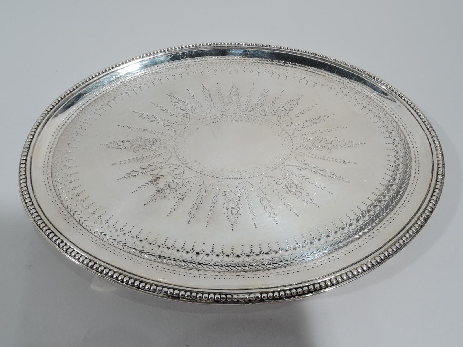 George III sterling silver salver. Made by Elizabeth Jones in London in 1784. Each: Oval with beaded rim and 4 beaded triangular supports. Neoclassical ornament including large central patera (vacant) engraved on well. Fully marked. Weight: 13 troy