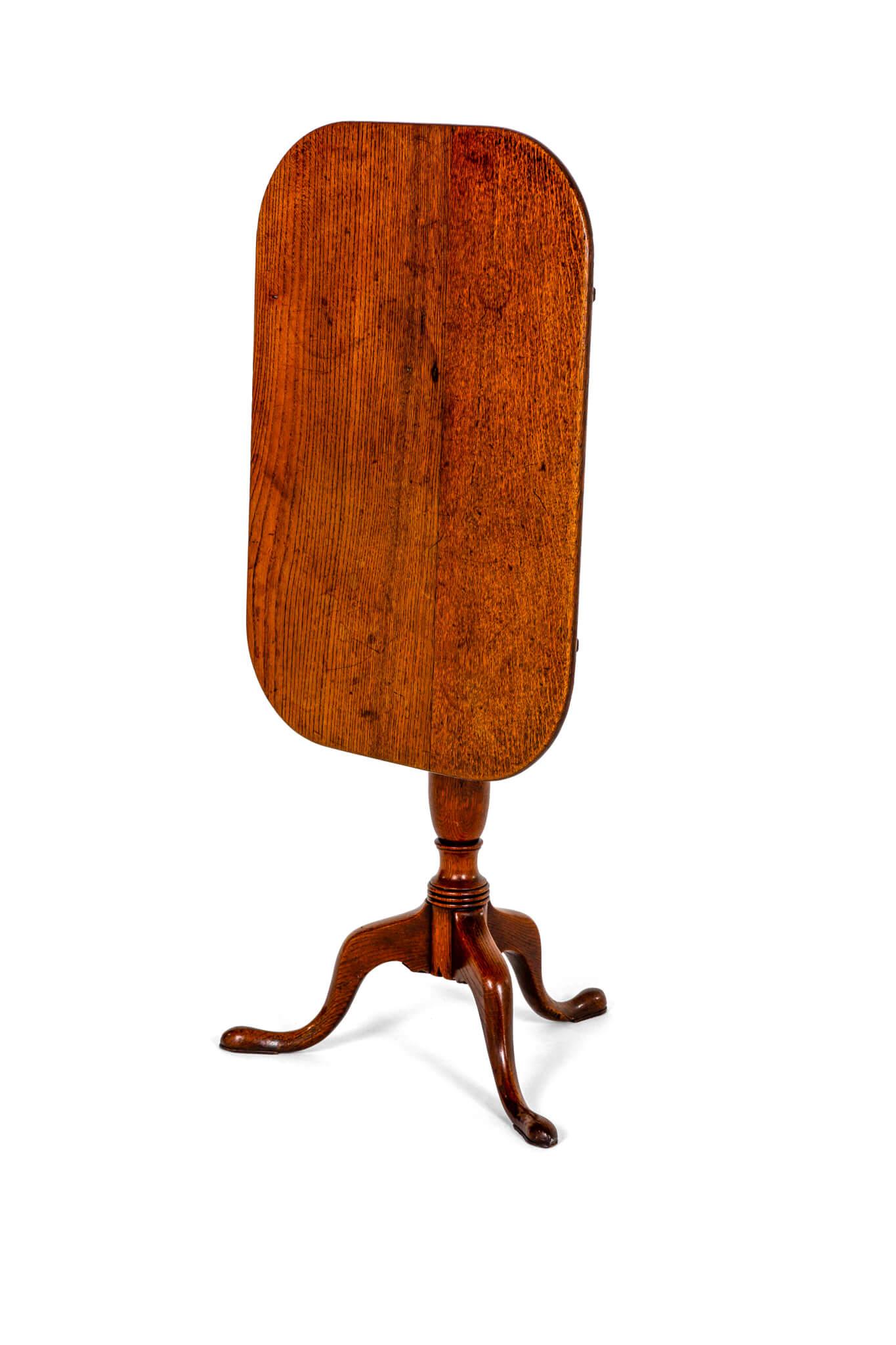A demure Georgian oak tripod table with a rounded oblong tilt top.

Raised on a turned vase stem with cabriole legs and pad feet.

Wonderful light chestnut shade throughout in wonderful country house condition.

English, circa 1800.

H: 72.5 CM  H: