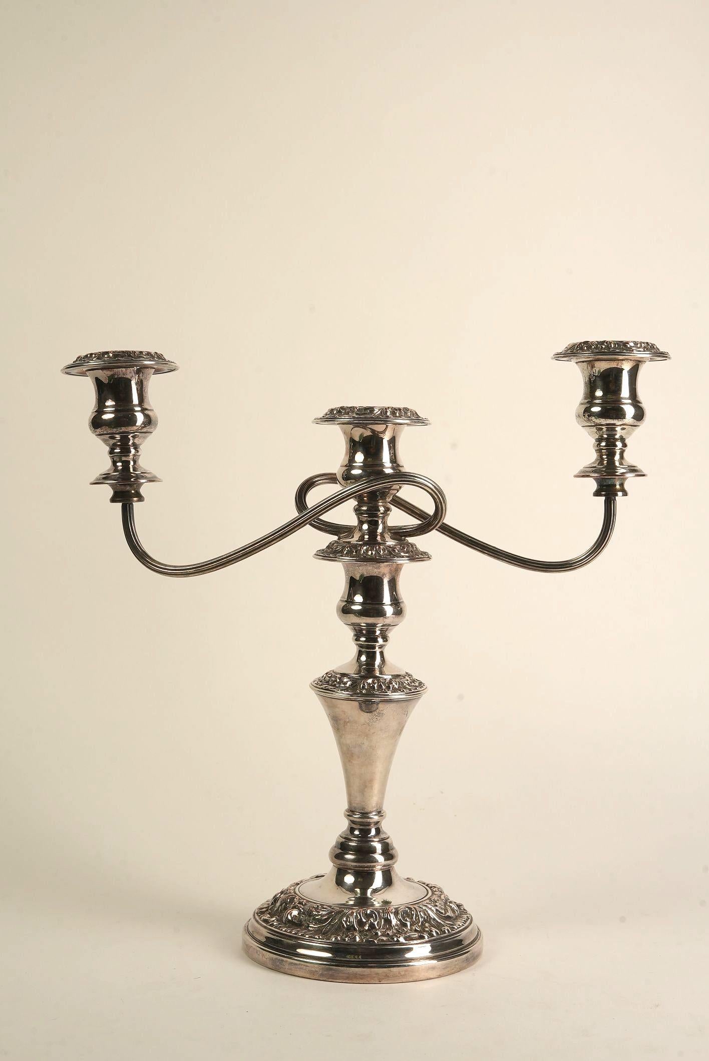 An embodiment of Georgian elegance, this three-arm Old Sheffield candelabra harks back to 18th-century England—an era marked by opulence, refinement, and exquisite craftsmanship. Old Sheffield Plate, an early method of silver plating developed in