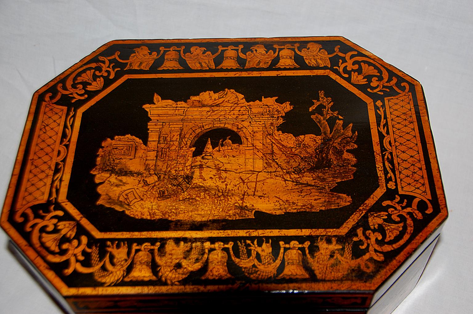 English Georgian penwork octagonal box with classical ruins on the lid and motifs from the great pyramids of Egypt in the borders and on the sides. After Horatio Nelson's victory in the Battle of the Nile in 1798, there was a flurry of decorative