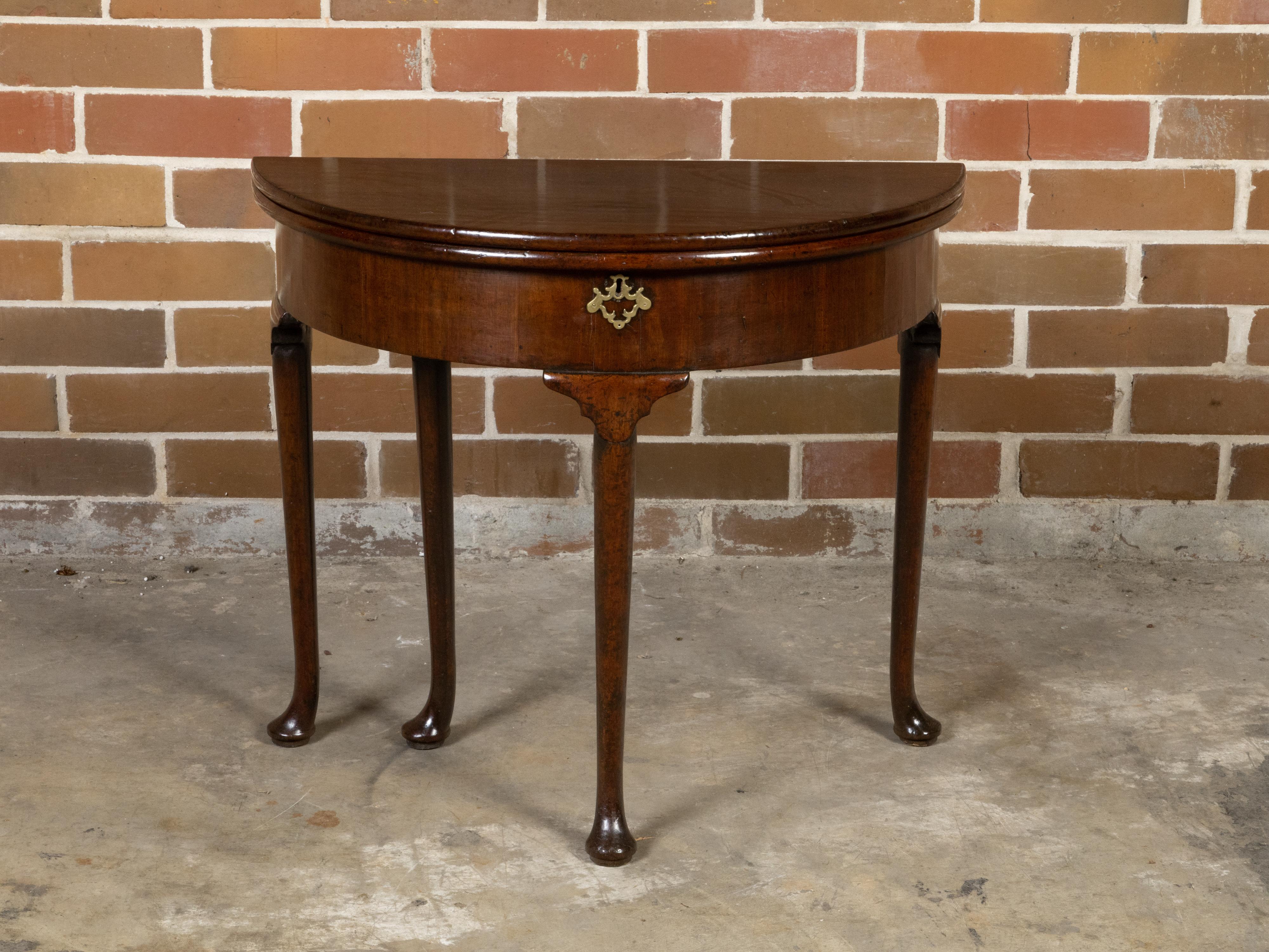 An English Georgian period demi-lune console table from the early 19th century, with flip top, leather inset and gilt frieze. Created in England during the Georgian period in the first quarter of the 19th century, this lovely demi-lune table