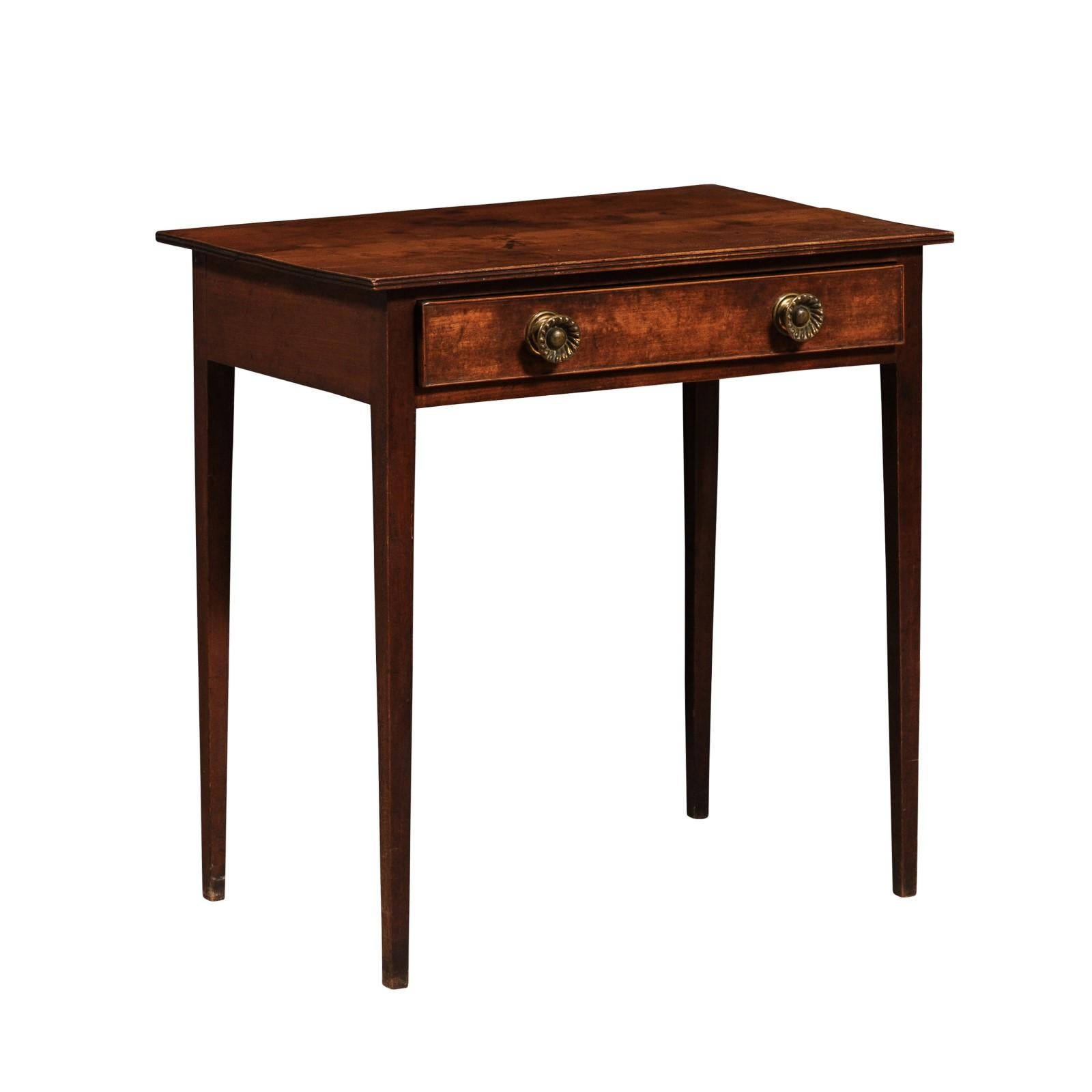An English Georgian period fruitwood side table from the 18th century with single drawer, double edge and tapered legs. Embrace the refined simplicity and timeless appeal of this English Georgian period fruitwood side table from the 18th century.