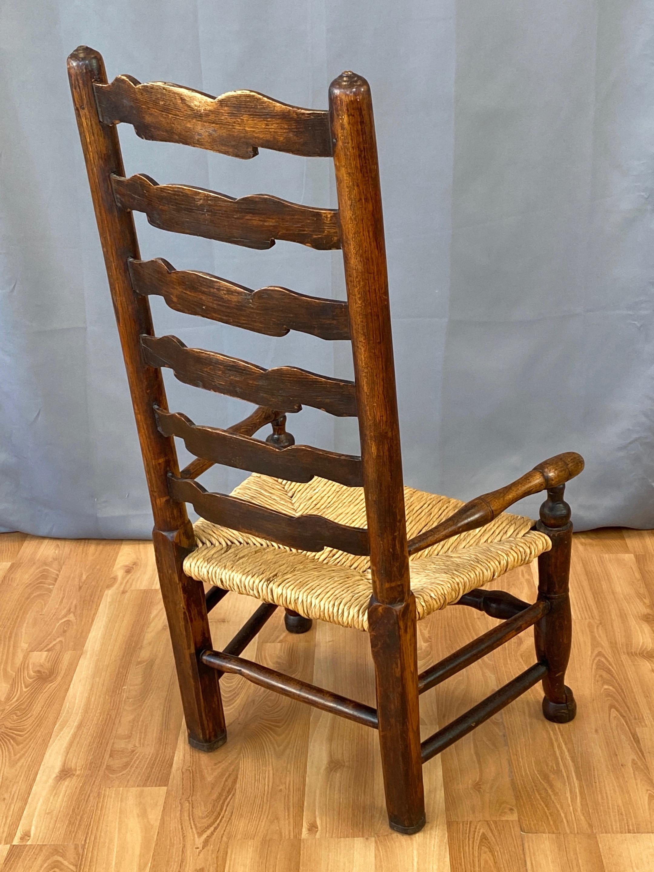 English Georgian Period Elm Ladderback Fireside Armchair with Rush Seat, c. 1800 In Fair Condition For Sale In San Francisco, CA