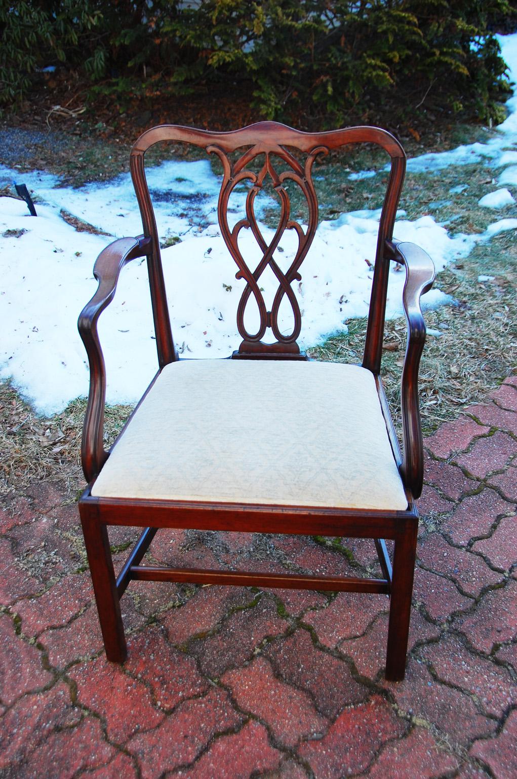 Englischer Chippendale-Sessel aus georgianischem Mahagoni mit geschnitztem, geformtem Mittelteil, H-Bahre, Schlupfsitz (der Stoff ist nicht neu, aber brauchbar), quadratische Beine. Die zentrale Leiste ist eine anmutige Verflechtung von