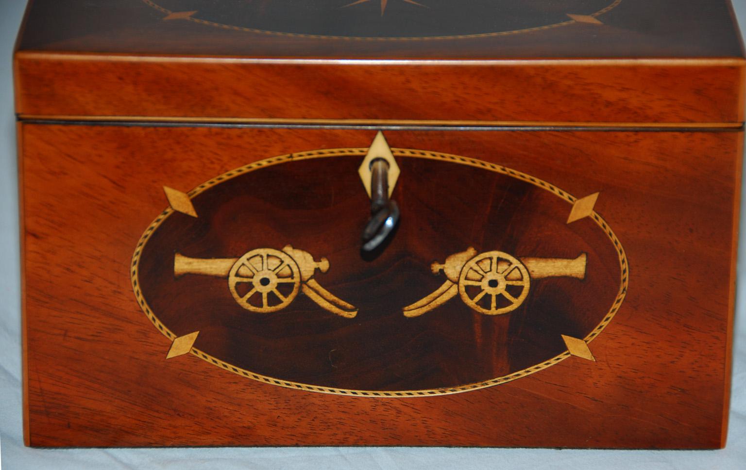 English Georgian military themed inlaid mahogany teacaddy. I believe this caddy must have been made to order for a military officer, as I have never seen this particular inlay of two canons and a compass rose on a tea caddy before. Even the edging