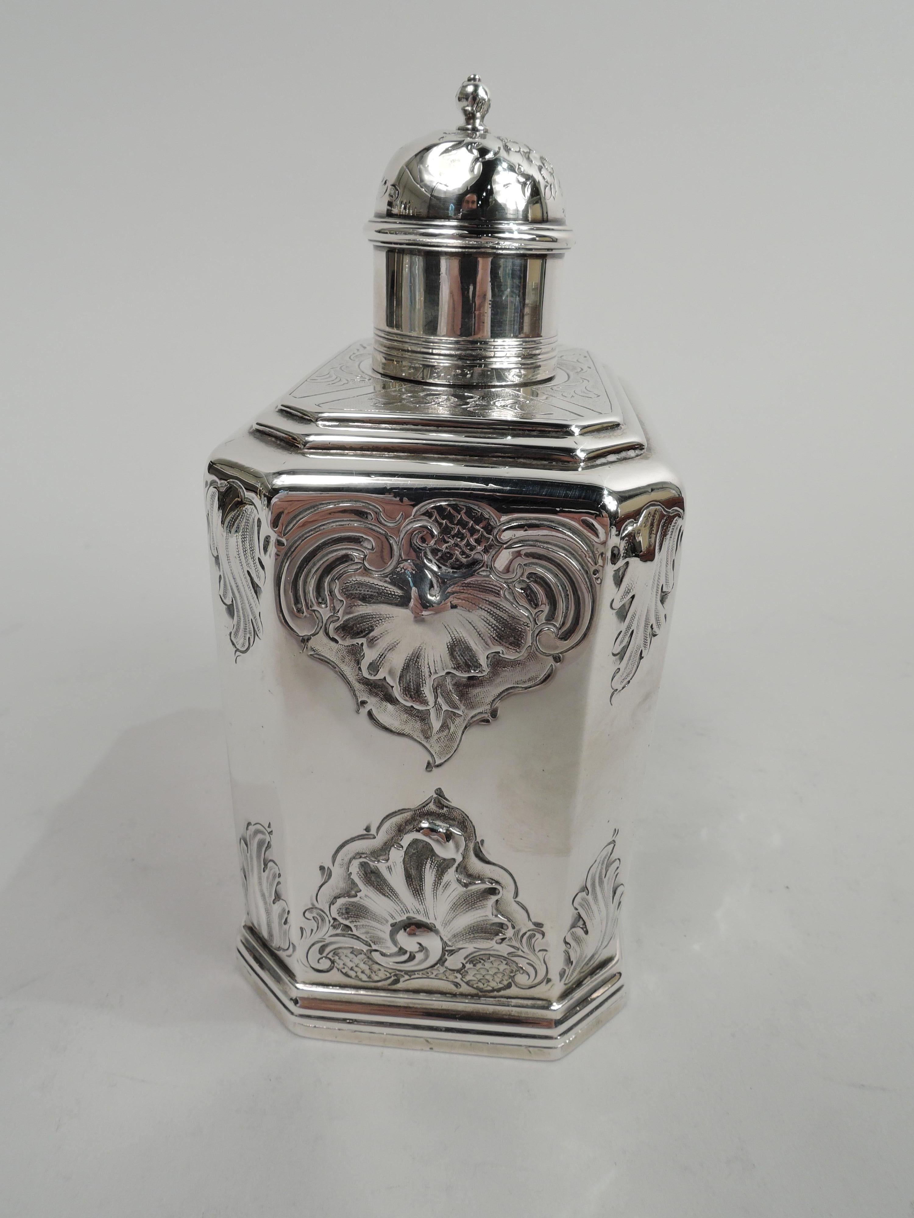 George IV sterling silver tea caddy. Made by Charles Fox II in London in 1833. Rectilinear with chamfered corners, reeded base, and stepped top. Push-and-slide panel at bottom. Neck short and straight, and cover domed with ball finial. Chased and