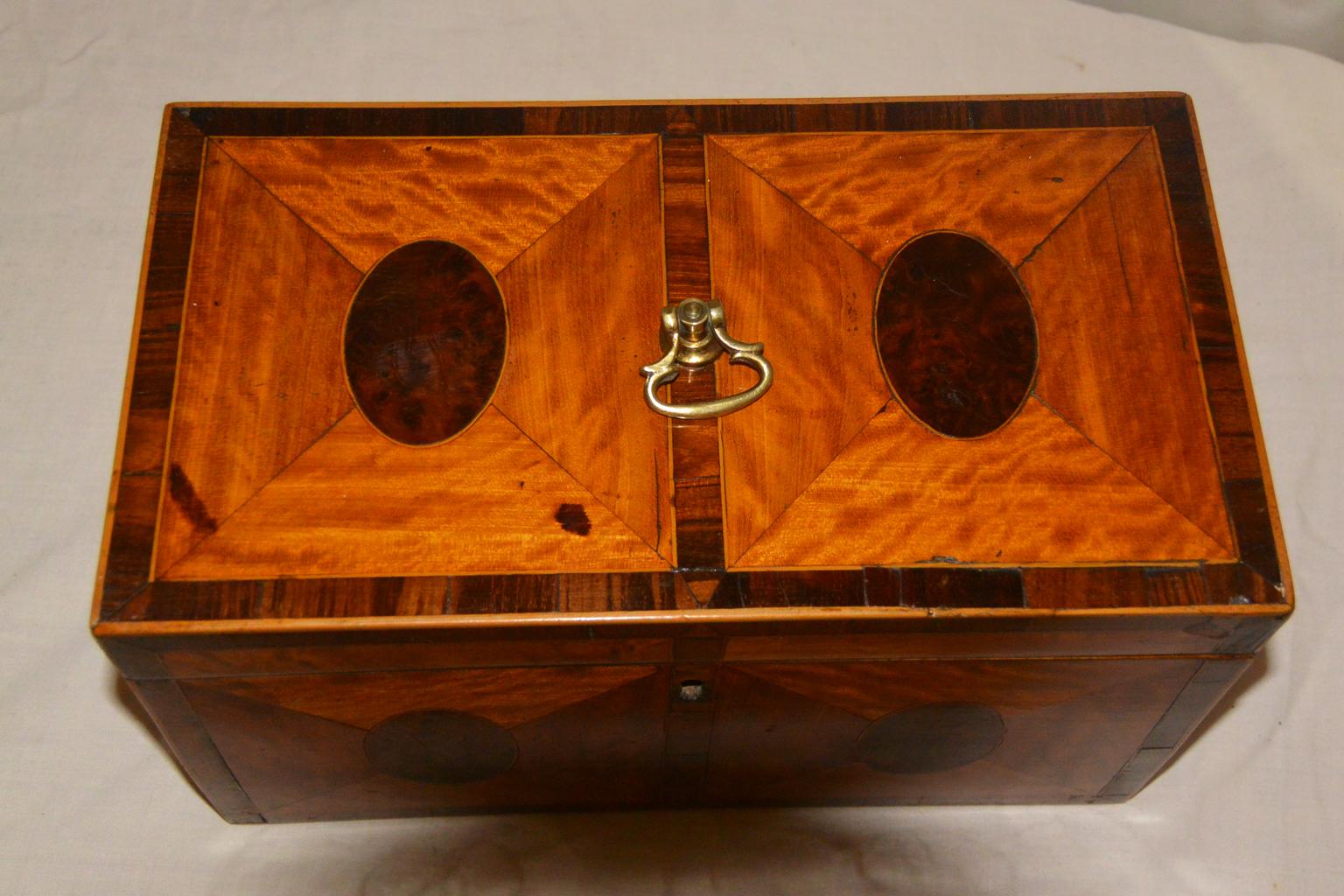 English George III satinwood double tea caddy with oval burl walnut inlays to all sides and the top. The kingwood crossbanding is enclosed by a thin line inlay of boxwood and is on all sides and the top. The interior lids have the same pattern of