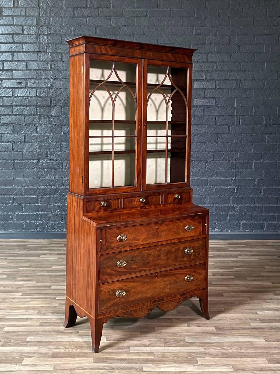 Condizioni: Condizioni originali d'epoca 

Materiali: Mogano a fiamma, maniglie in ottone patinato, scrivania con superficie in pelle, vetro originale

Questa libreria georgiana in stile Sheraton Revival, realizzata intorno al 1900, fa rivivere la