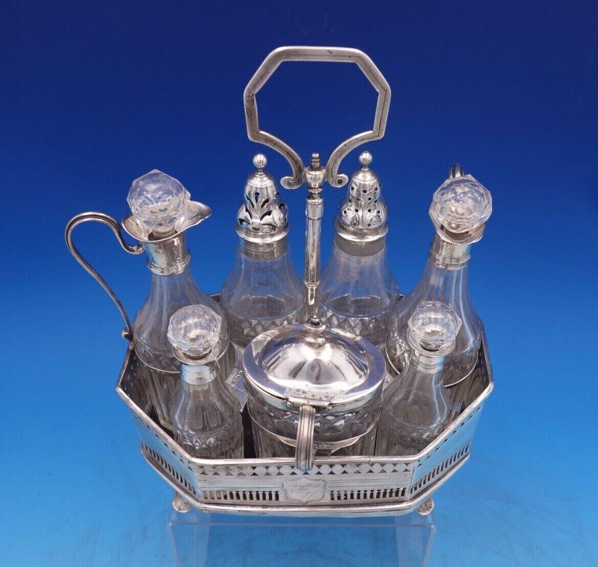Fabulous English Georgian sterling silver seven piece cruet set with stand made in London circa 1793. This set includes bottles for salt, pepper, mustard, oil, vinegar, and two smaller jars. The stand is pierced and footed, and has a handle and a