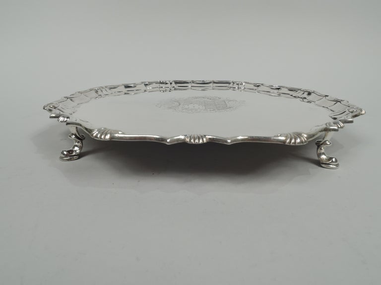 George II sterling silver salver. Made by Robert Abercromby in London 1741. Molded scroll and shell rim and 4 scroll-mounted hoof supports. Armorial engraved in well center. Great heft and balance. Fully marked. Weight: 28.7 troy ounces.