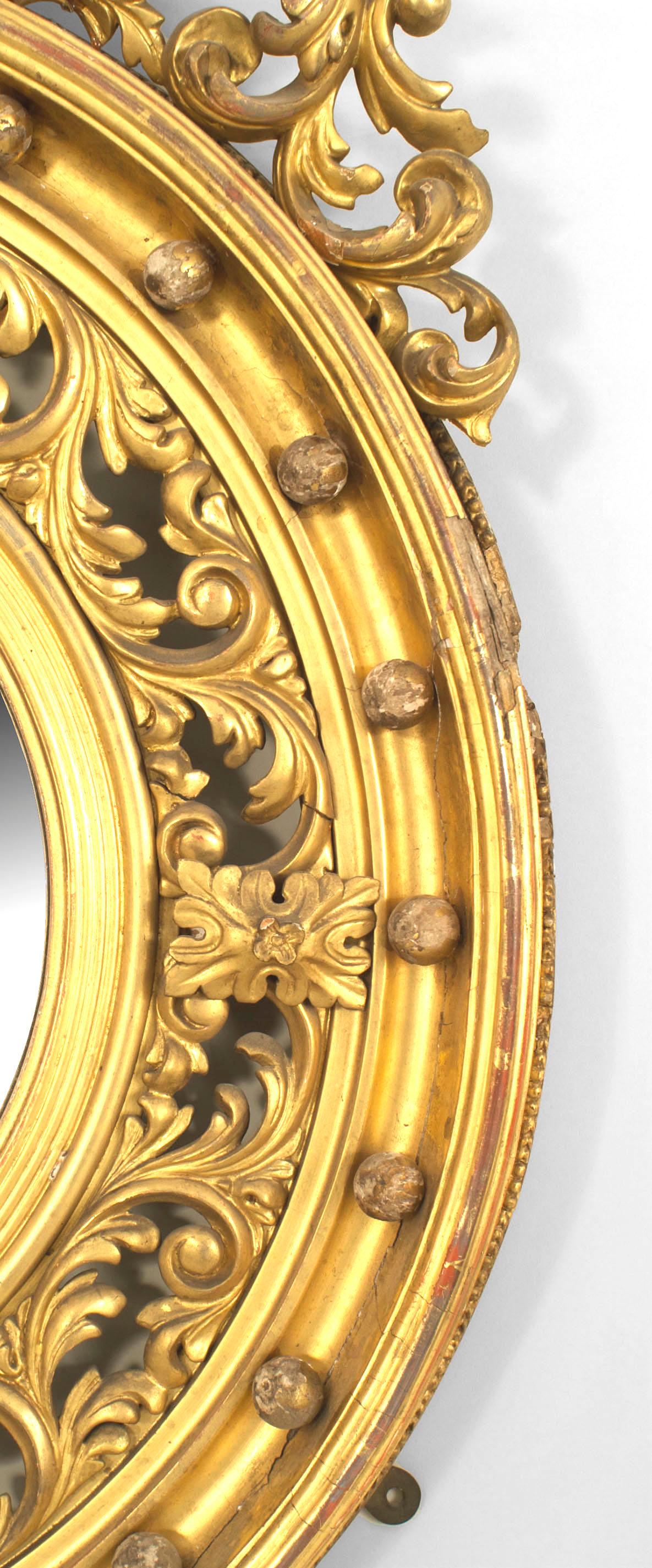 English Georgian style, 19th century gilt round convex wall mirror with filigree carved scroll design and eagle top.
 