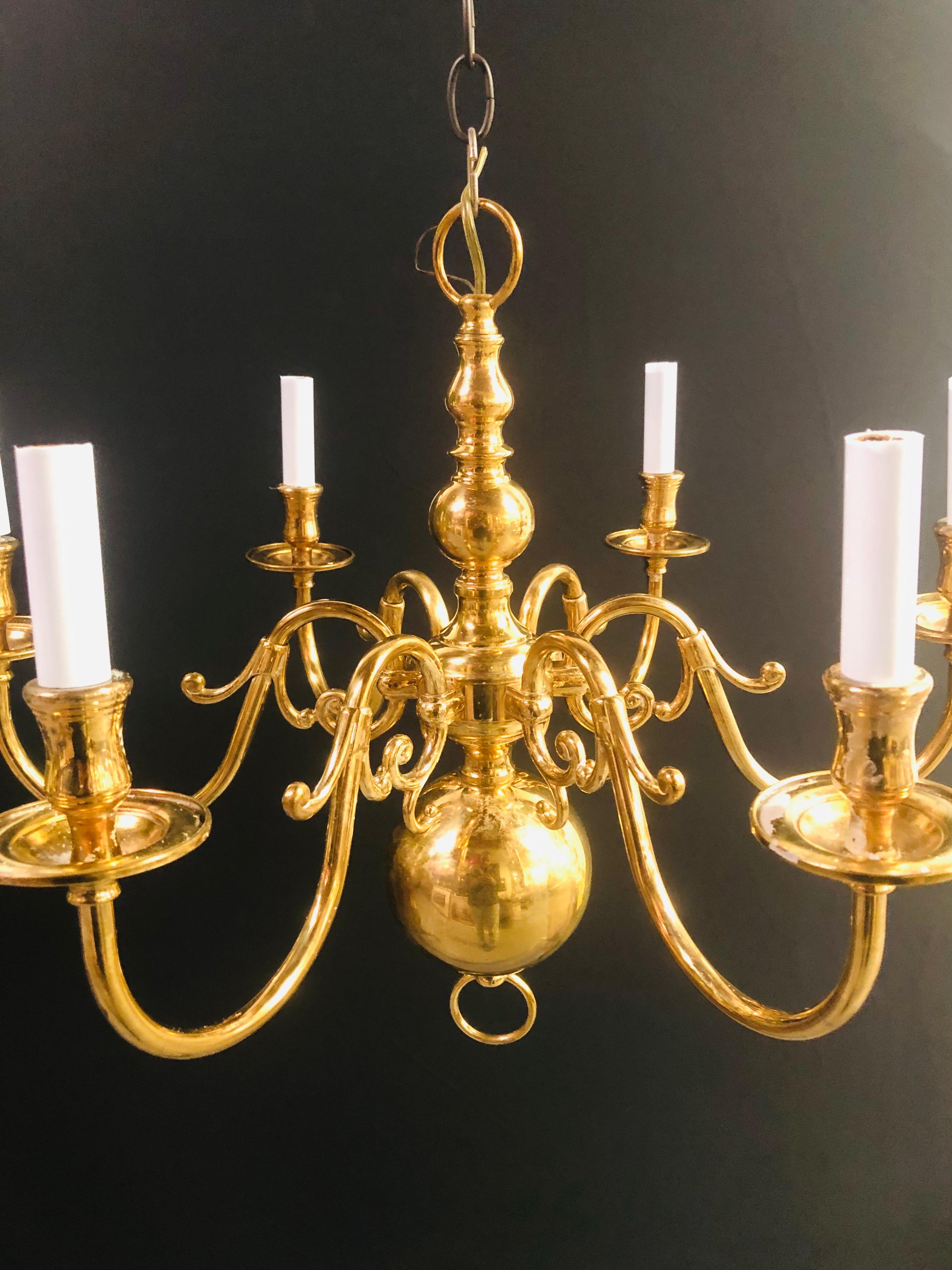 A Classic solid brass English Georgian style chandelier holding 6 candelabras and featuring fine arms ending in scroll design. The chandelier column ending in a large ball shaped bottom 

Georgian brass chandelier with 6 arms. Dimensions: 19