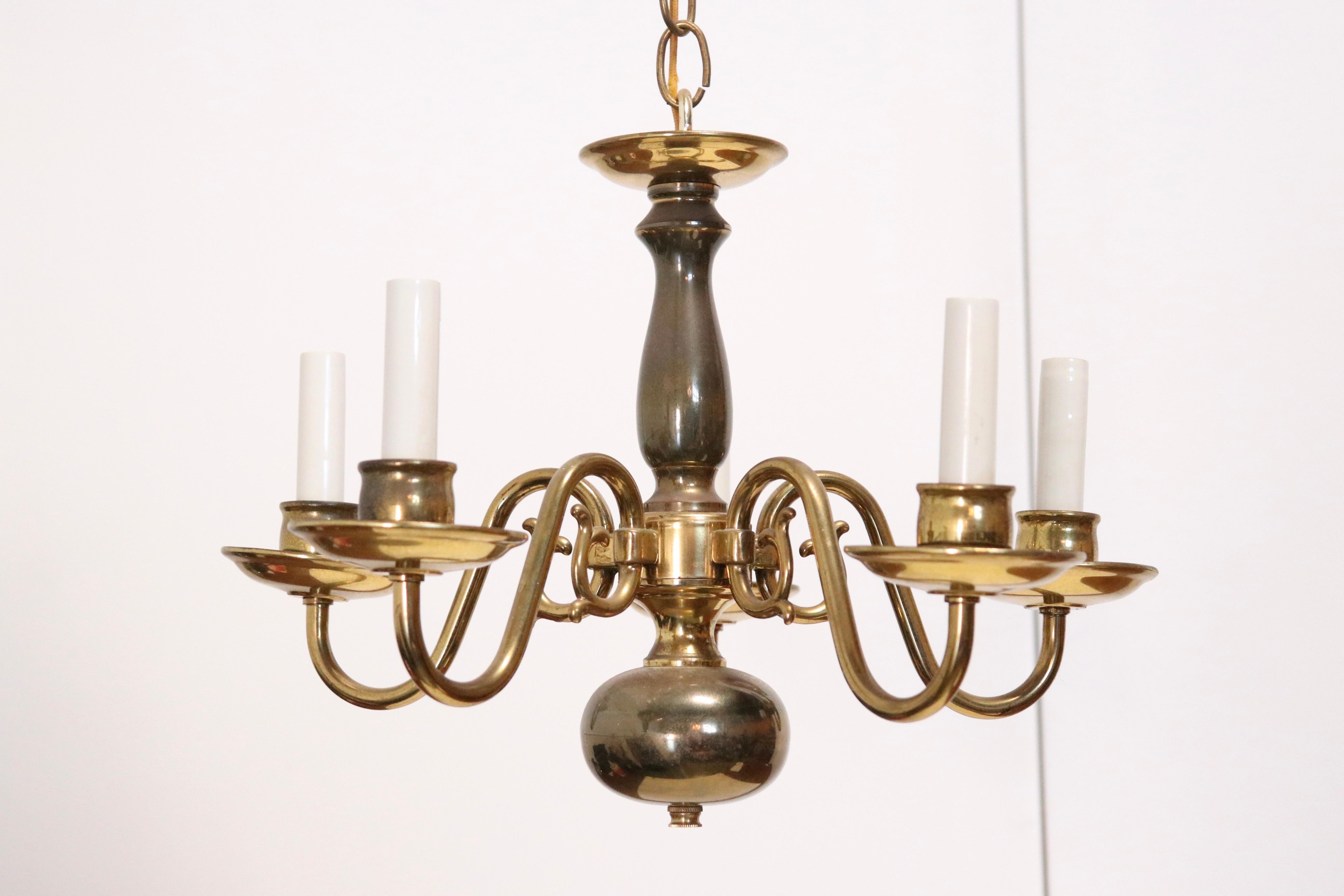 A Georgian-style petite chandelier with x electrified arms, in polished brass with a patinated brass center stem. Features classic English design elements including urn shape in the post and large globe below, with each curved scroll arm culminating