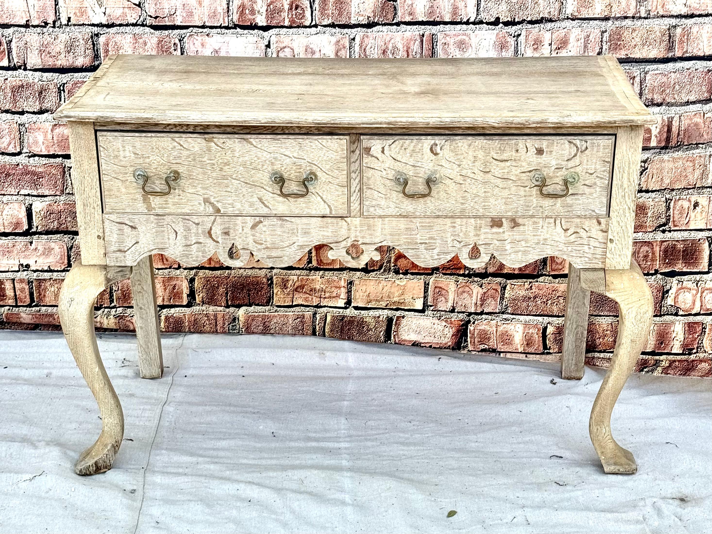 19th Century English Georgian Style Carved and Banded Oak Lowboy.
Table has a rectangular top over two setback frieze drawers above a pierced skirt, on cabriole legs with pointed pad feet. Wonderfully bleached oak finish.