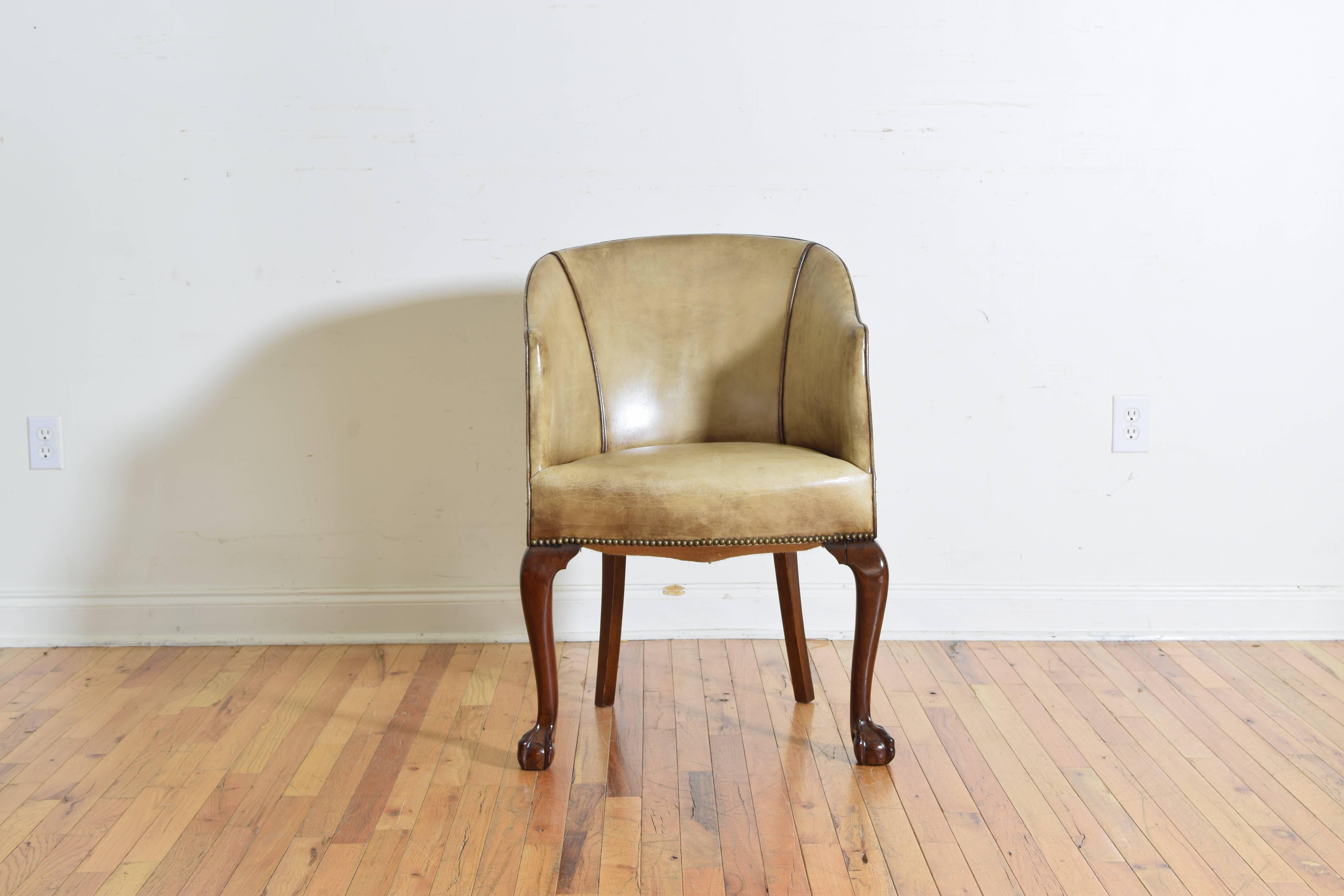 Having an enclosed leather upholstered back divided into panels by patinated brass nailheads, the front cabriole style legs ending in carved ball and claw feet, the rear legs are splayed.