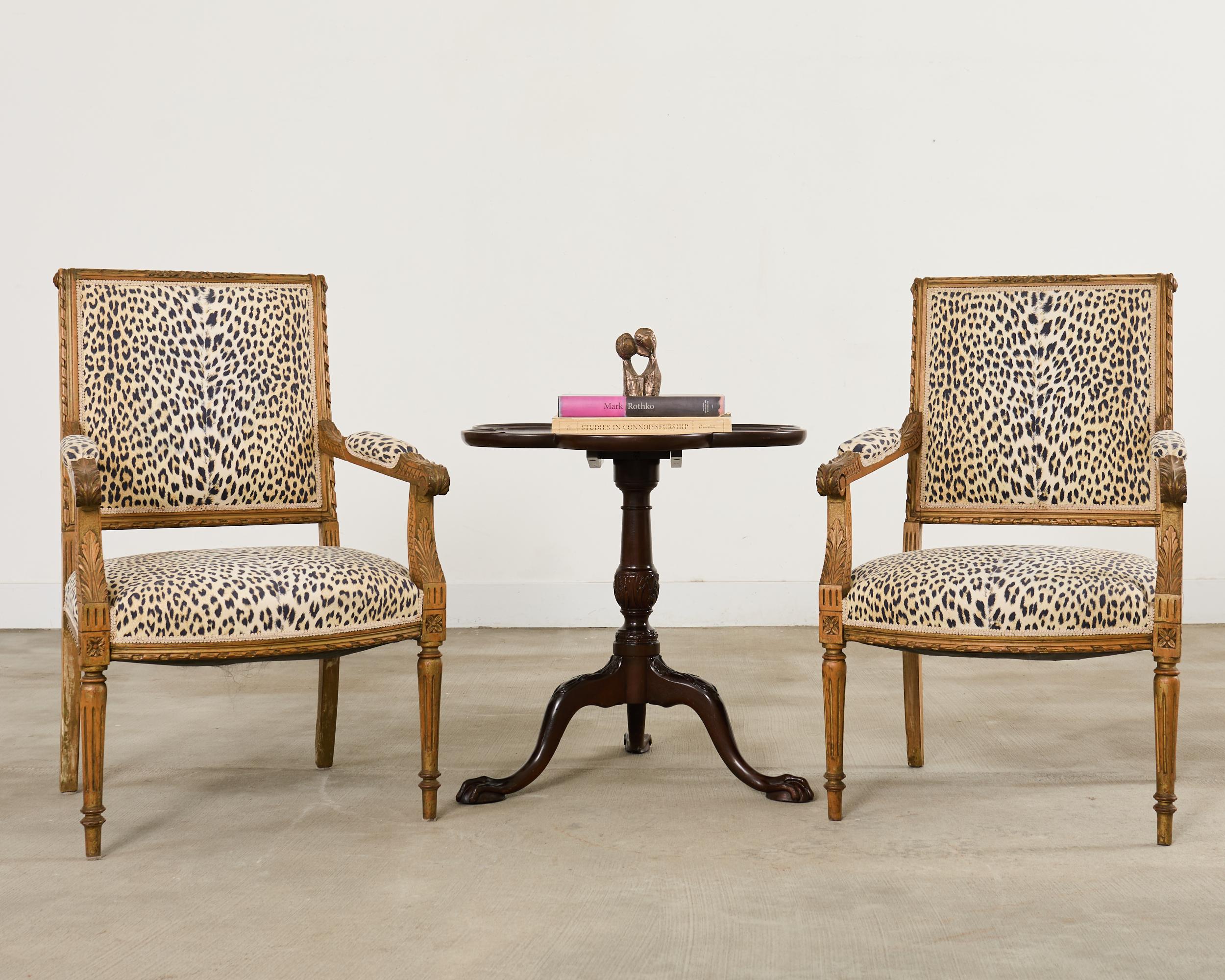 Handsome English mahogany flip-top side, end, or dessert table featuring a clover leaf shaped top. The top is supported by a turned column having cabriole shaped tripod legs ending with ball and claw feet. The legs and column are decorated with