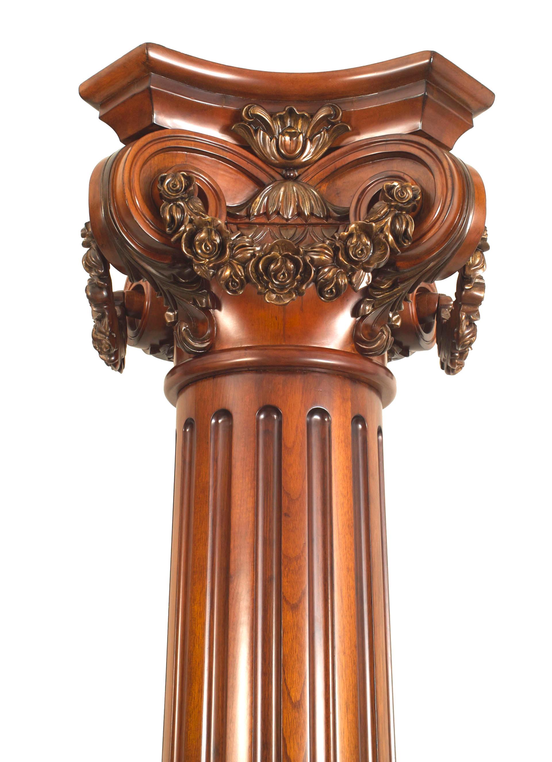 Pair of English Georgian style (20th Century) mahogany fluted large columns with a carved capital having a garland and resting on a square base (PRICED AS Pair).
