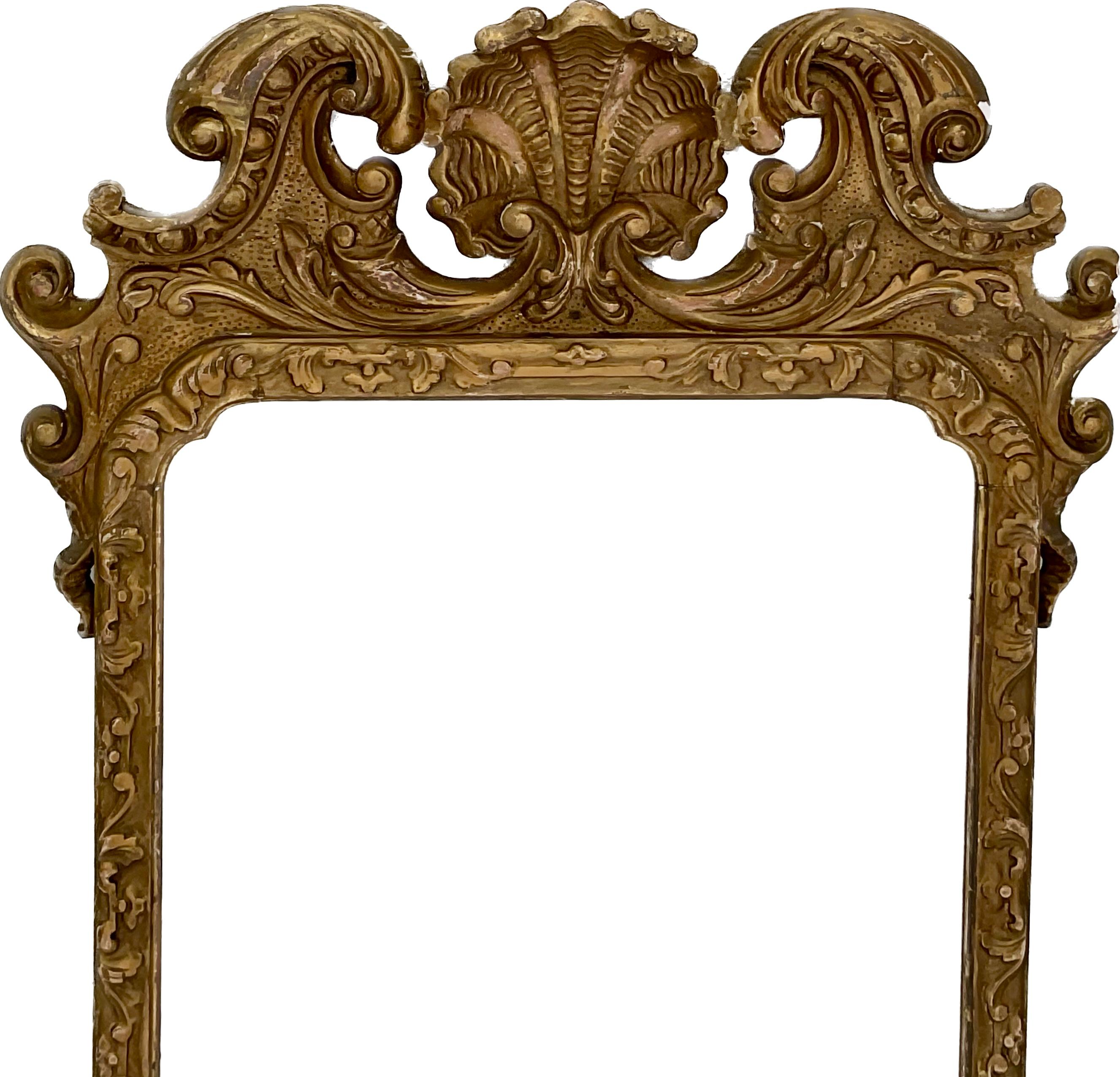 A good English Georgian style gilt wood carved  mirror having a shell and broken arch pediment  crest over beveled mirror plate. Labeled A.W.  Johnson Gilder and Picture frame maker 152 High  Street Kensington. 