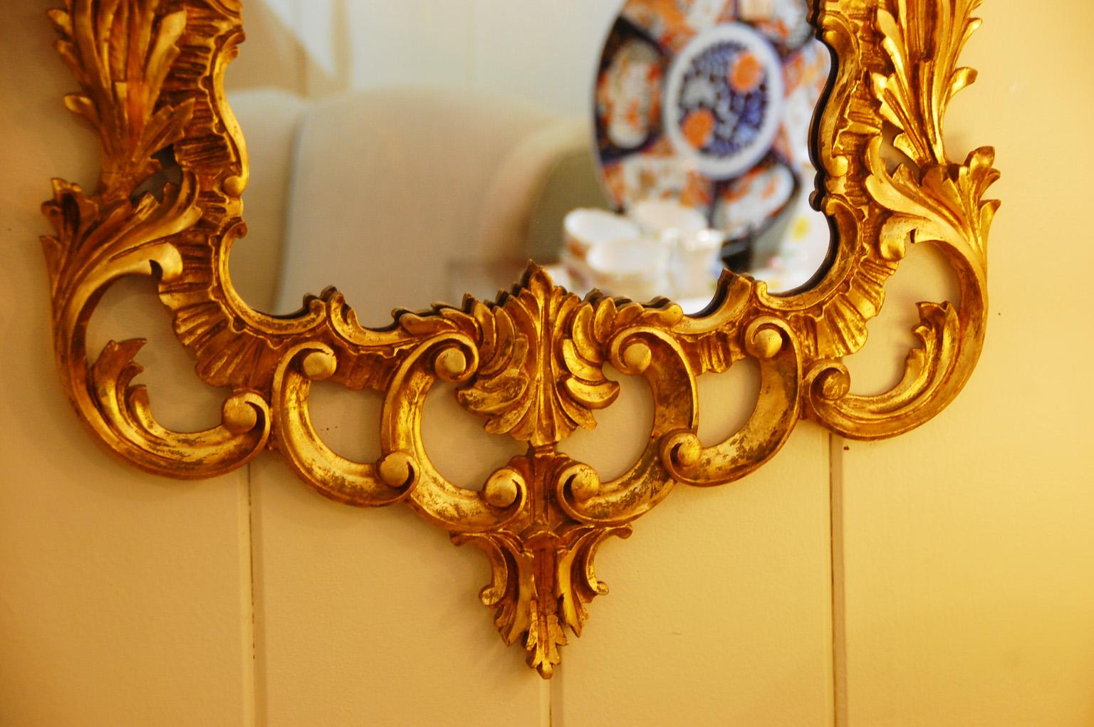 English Georgian style late 19th century gold leaf hand carved mirror. This elegant wood carved mirror has acanthus leaf and flower motifs and is in excellent condition. At 22