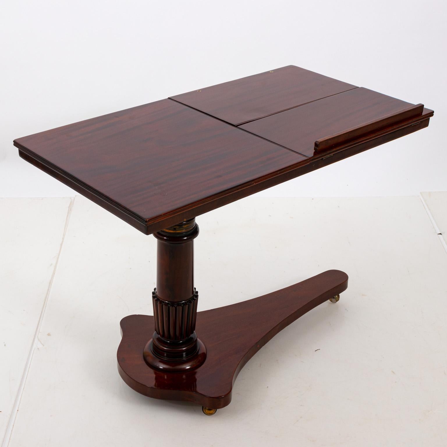 English mahogany pull up reading table on castors in the Georgian period style, circa 19th century. The piece also features an adjustable height along with two closable book stands and interchangeable book guard. Please note of wear consistent with