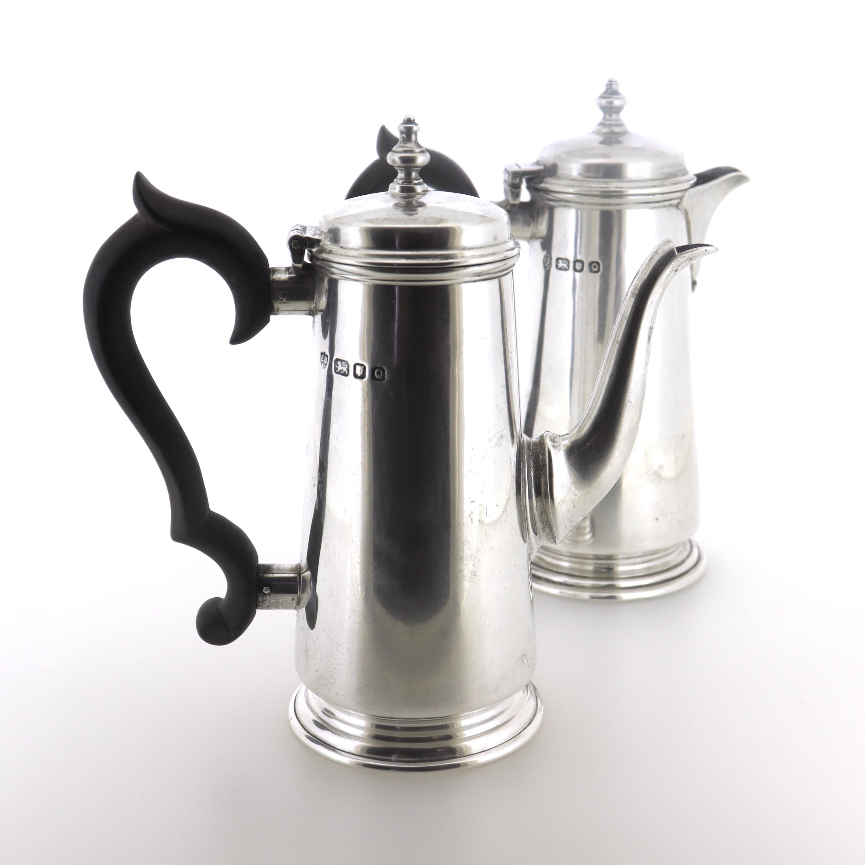 A fine set of a vintage English Georgian style dollhouse miniature or child's size lighthouse teapot and a chocolate pot.

In sterling silver.

In the form of lighthouse pots.

Each with sterling silver bodies, hinged lids, and wooden handles.