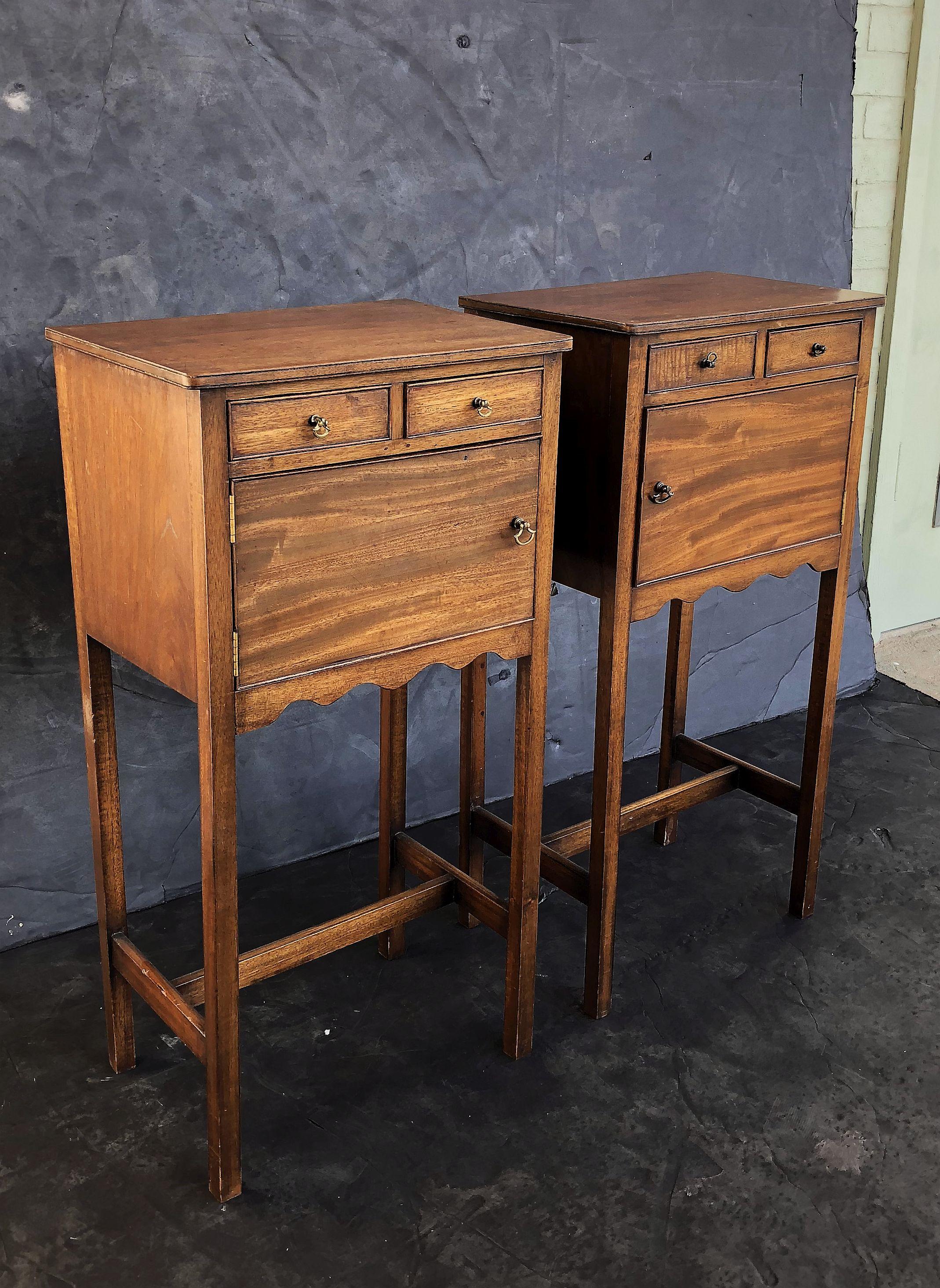 A pair of fine English nightstands or bedside end tables, in the Georgian style, each featuring a moulded top over a frieze with two small beaded drawers over a beaded cupboard door, with a scalloped edge detail, and set upon a four leg support with