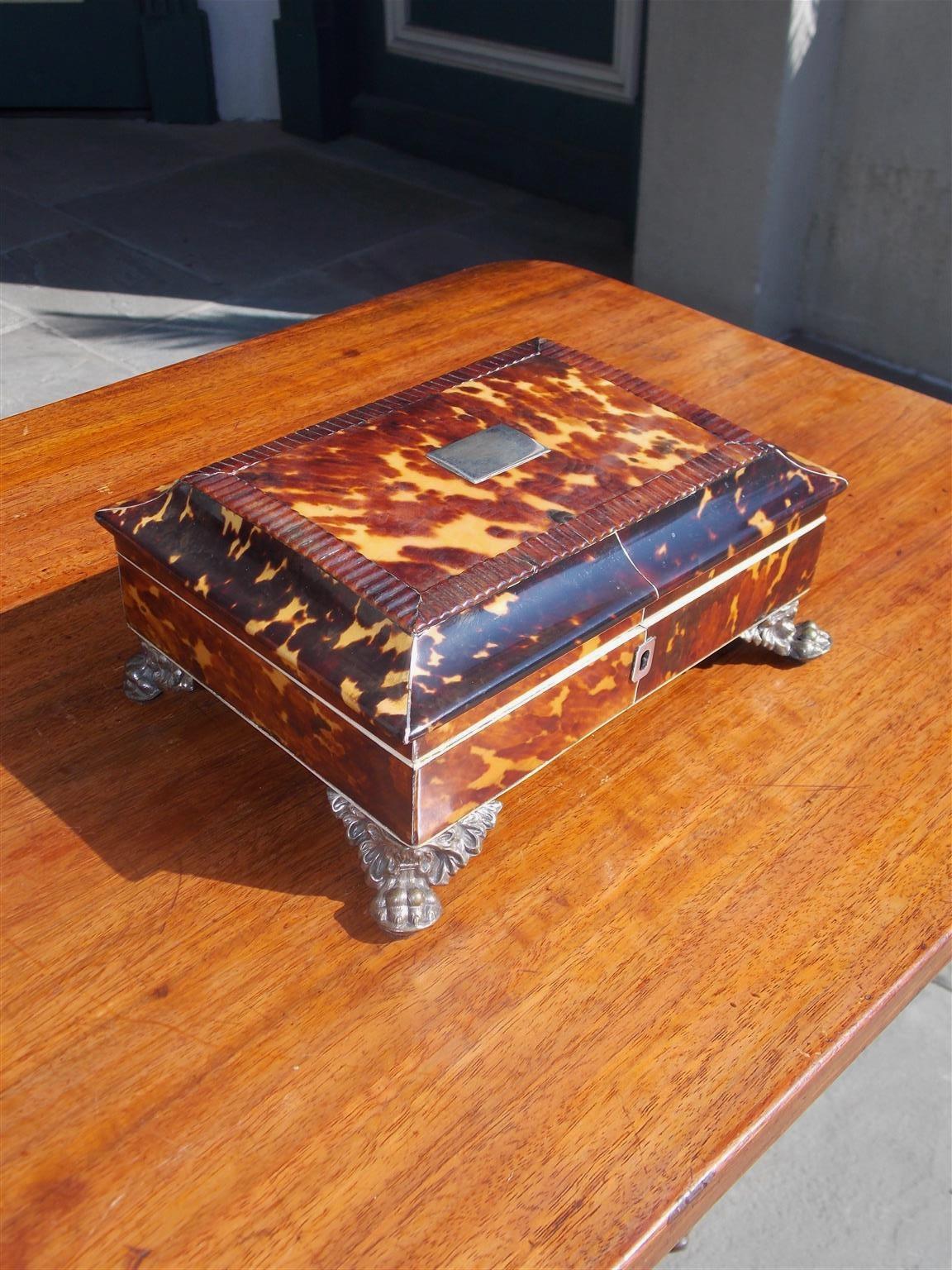 English Georgian Tortoise shell hinged sewing box with a gadrooned molded edge lid, fitted tufted interior, and resting on the original silver plate winged paw feet. Early 19th Century