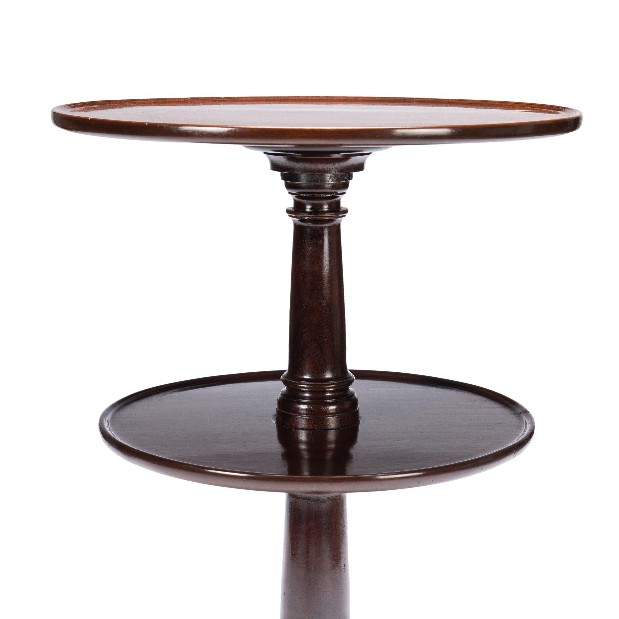 A rare form of Georgian two tier circular dumbwaiter in Cuban mahogany. The design features reverse graduated revolving dish tops with a turned columnar pedestal on tripod cabriole legs with slipper feet. The dumbwaiter can be partially disassembled