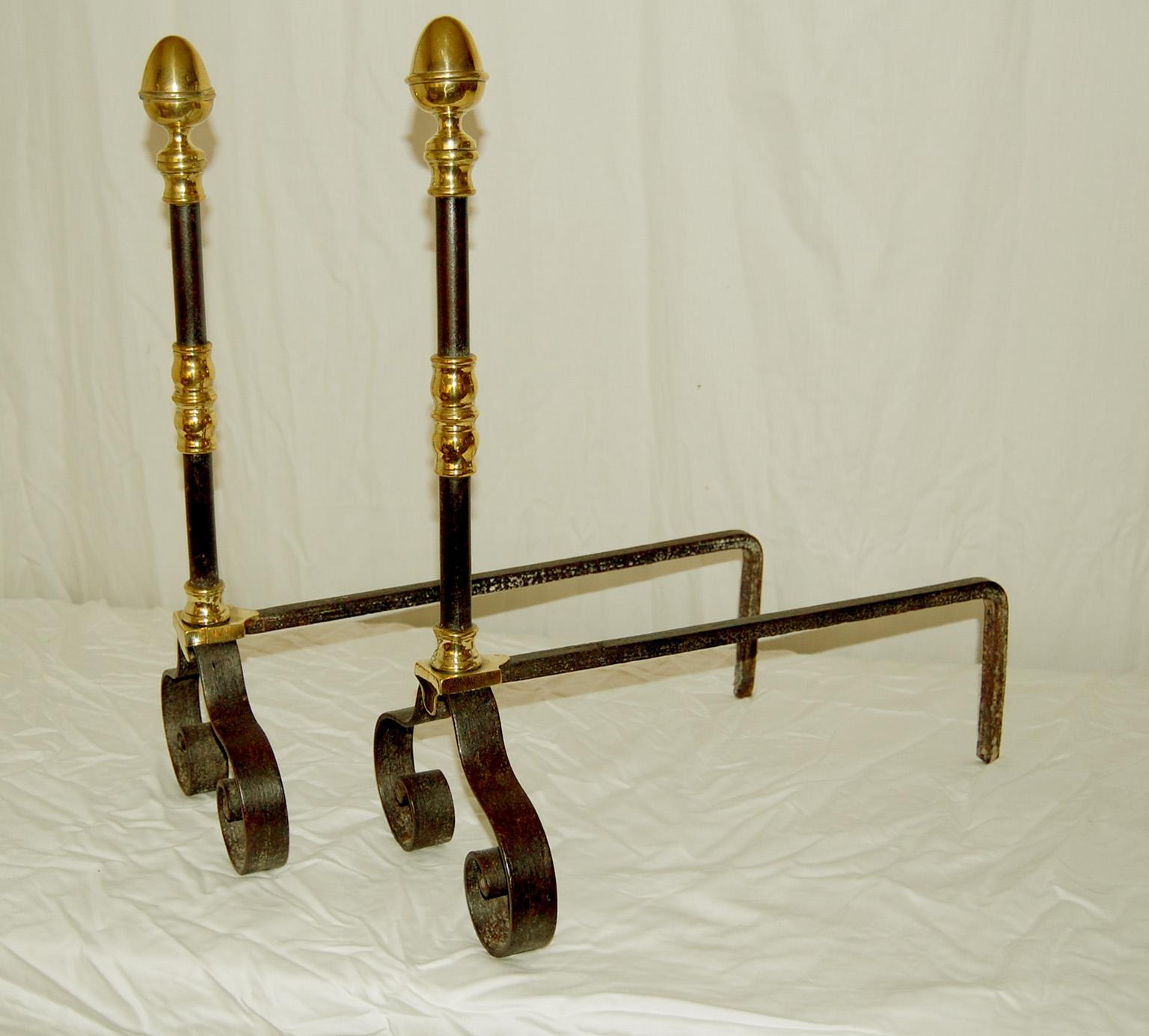  English wrought iron and brass Georgian andirons with swirl feet and acorn finials.  This combination of iron and brass is often used in sophisticated but less formal settings, the swirl feet add stability and create a lovely pattern against the