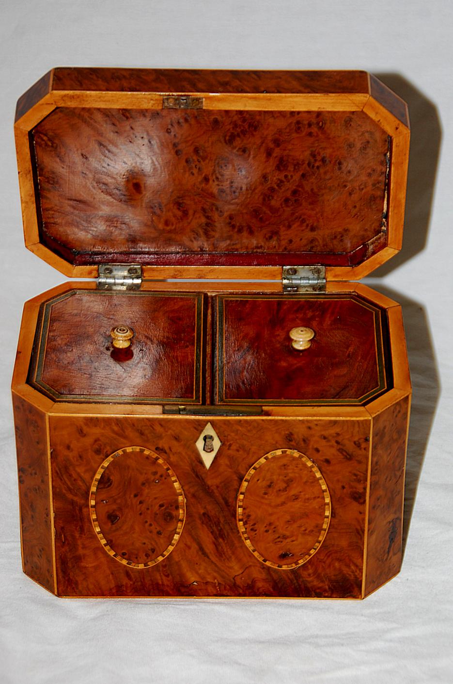 English Georgian Period yew wood octagonal tea caddy with oval inlays on five sides. The ovals are incased by a line inlay made up of tiny squares of sycamore, satinwood and rosewood and further encircled by a very fine boxwood single line inlay.