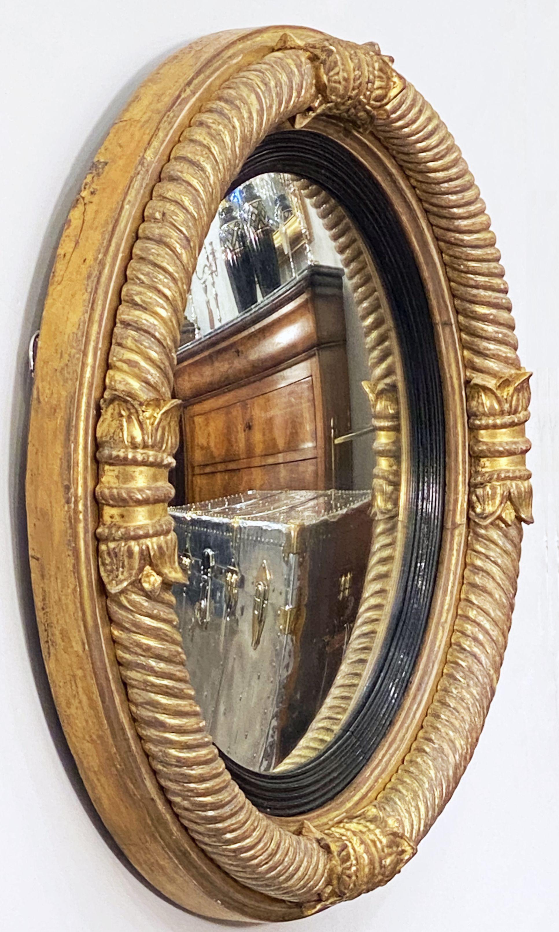 Un beau miroir convexe anglais d'époque Régence avec un design de colonnes classiques arquées autour d'une circonférence extérieure nervurée avec des traces de la dorure originale d'époque, et un anneau intérieur ébénisé et cannelé. 

Le cadre