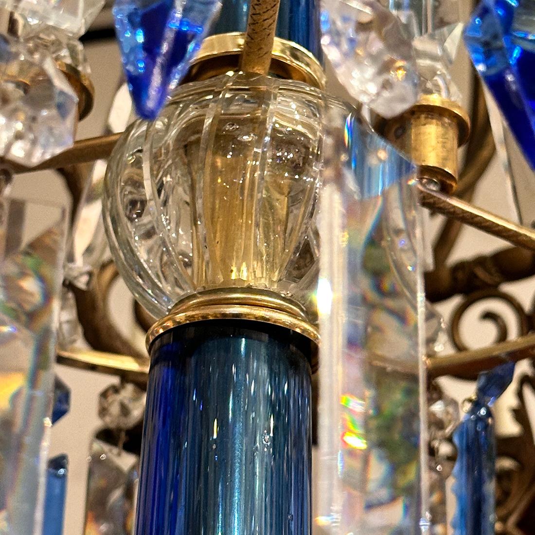Lustre anglais en bronze doré des années 1920 avec pendentifs en cristal bleu et 12 bras.

Mesures :
Chute : 56